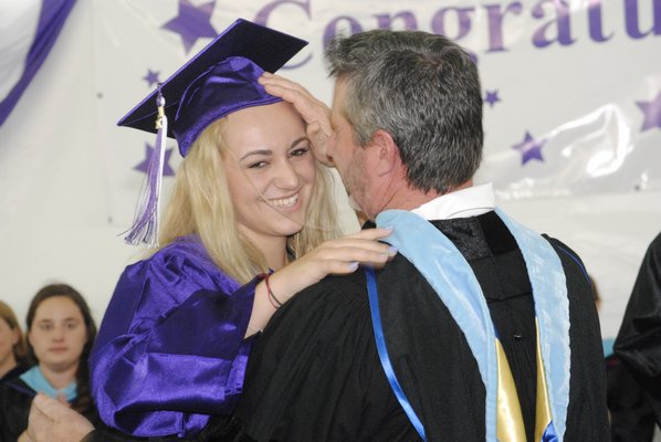 Kylie Springer embraces her father, Kevin Springer, the vice president of the Board of Education, during graduation on Saturday afternoon. AMANDA BERNOCCO