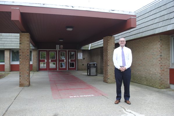 Superintendent Lars Clemensen stands in front of the enterance of the Hampton Bays High School, which will be under construction starting on June 26. AMANDA BERNOCCO