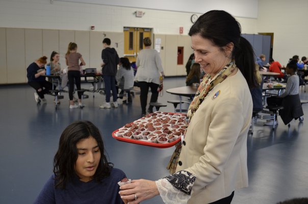 Regan Kiembock handing out beet muffins to students at Southampton Intermediate School. ANISAH ABDULLAH