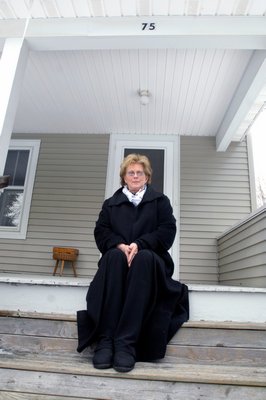 Judy Parker Musnicki sitting on the front porch of her family home. DANA SHAW