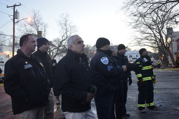 Fire and police officials survey the scene with Suffolk County Executive Steve Bellone and Southampton Town Supervisor Jay Schneiderman. JEN NEWMAN