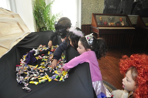 Trick-or-treaters grab a handful of candy at the Corwith House in Bridgehampton. MICHELLE TRAURING