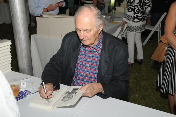 Alan Alda signs his book.
