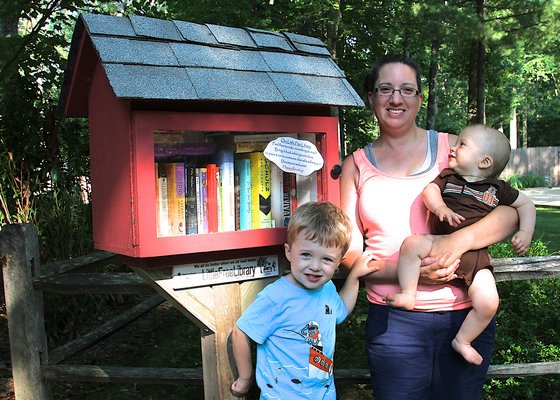 Catherine Mottola-King with her children Nathaniel and Timothy at their Little Free Library in Springs KYRIL BROMLEY