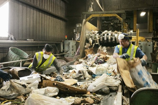 Workers pull material from the construction and demolition line at Paumanok Environmental in Yaphank. JOSEPH P. LOUCHHEIM