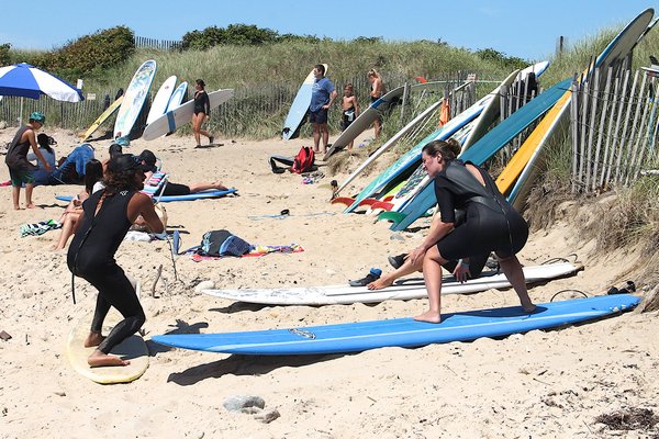 Instructors teach clients how to surf at Ditch Plains Beach on Tuesday. KYRIL BROMLEY