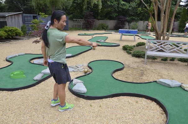 Khanh Ngo explains the portability of his new mini golf course behind his sports store on Montauk Highway. SHAYE WEAVER