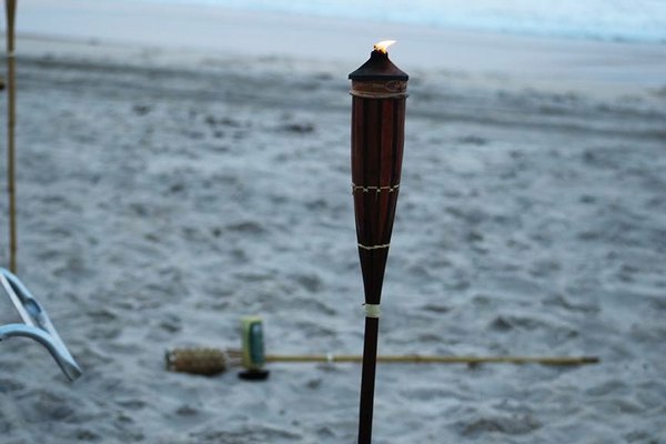 A Tiki torch is left burning from a beach party took place over the holiday weekend on a beach in East Hampton Village. FACEBOOK