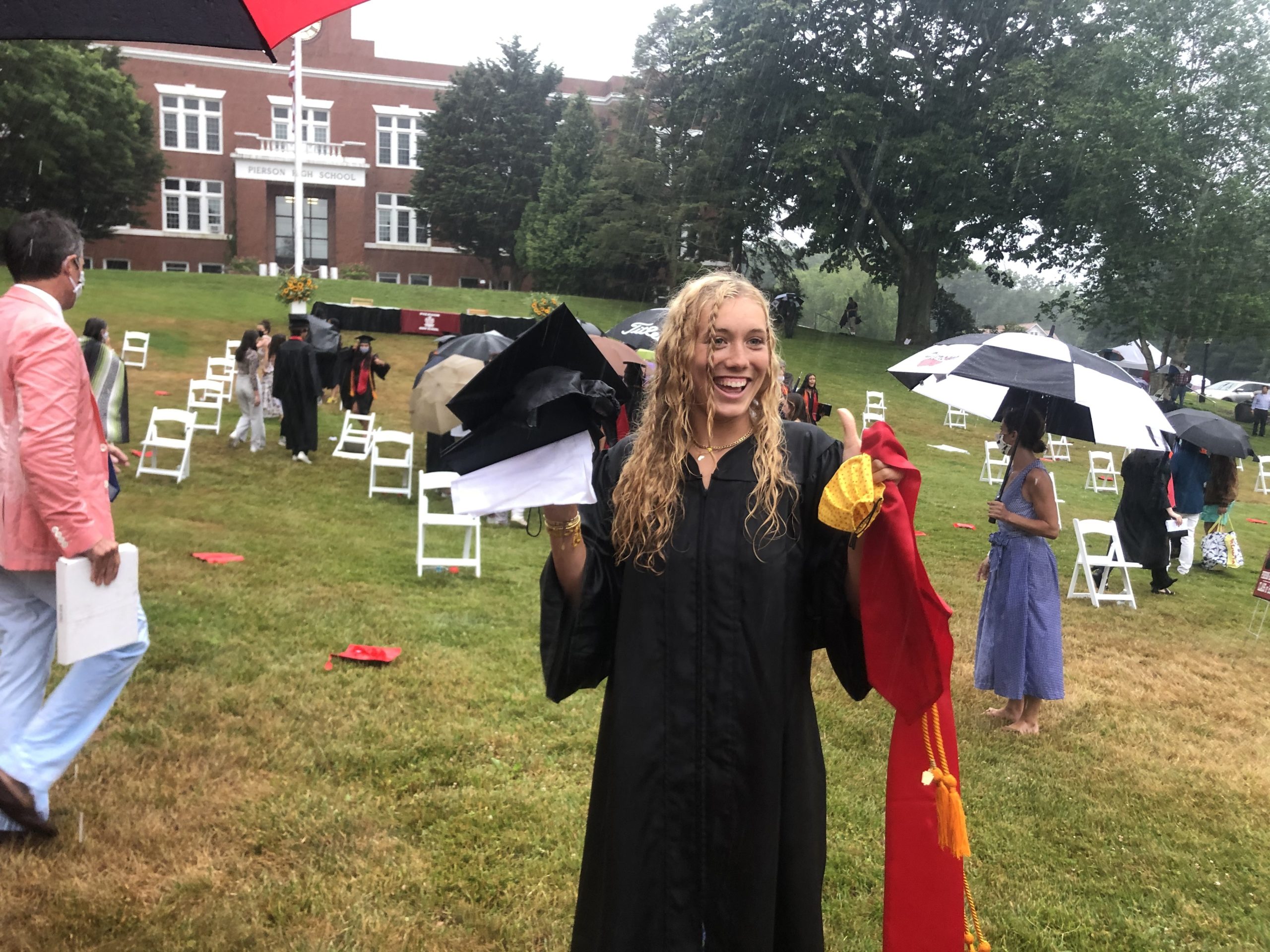 Cancer survivor Halle Kneeland dries off from a rainstorm after graduating from Pierson High School on June 27.