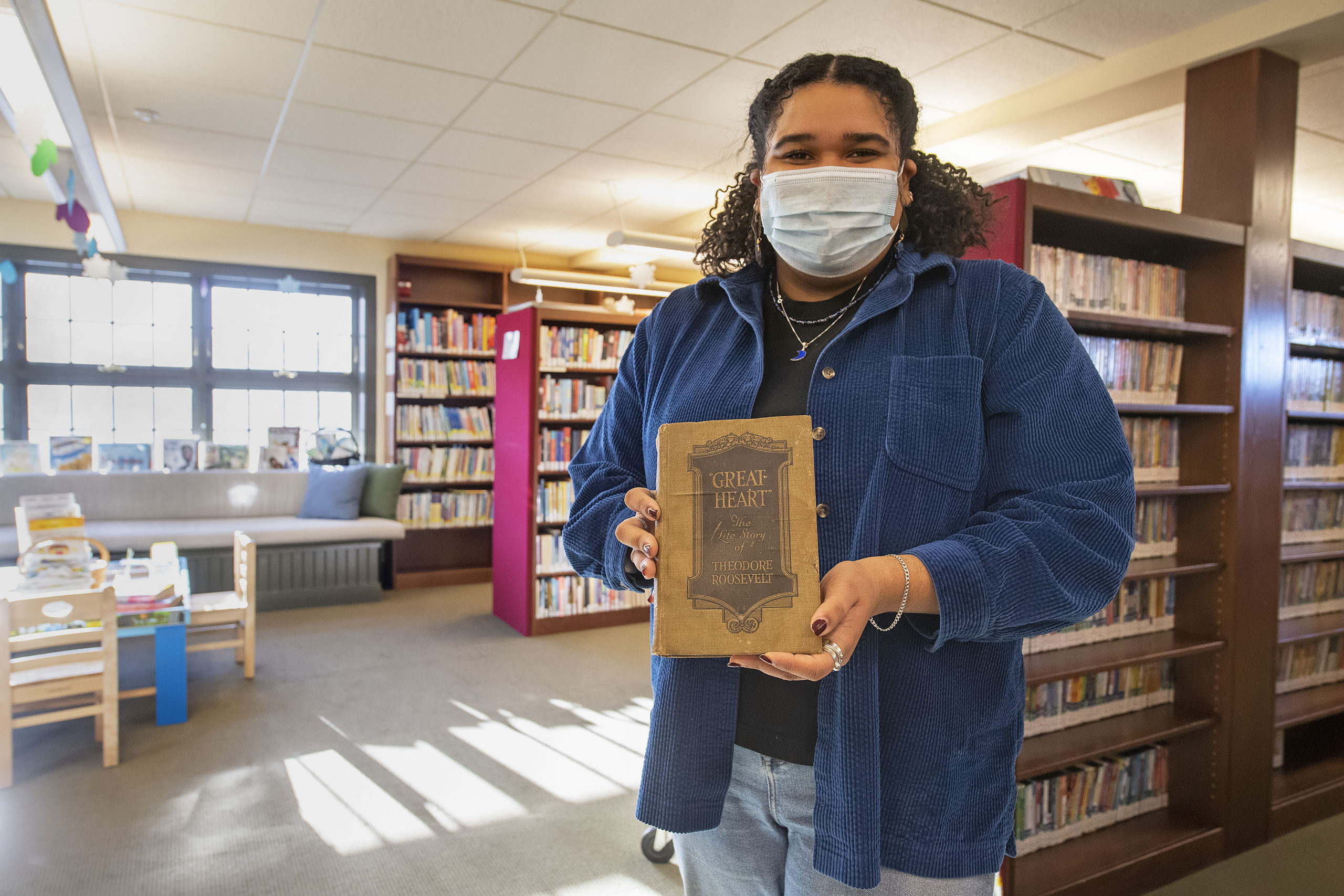Librarian Julianna Vargas accepted the overdue book from John Moss, who found it in a crate of old books he had ins storage. MICHAEL HELLER PHOTOS