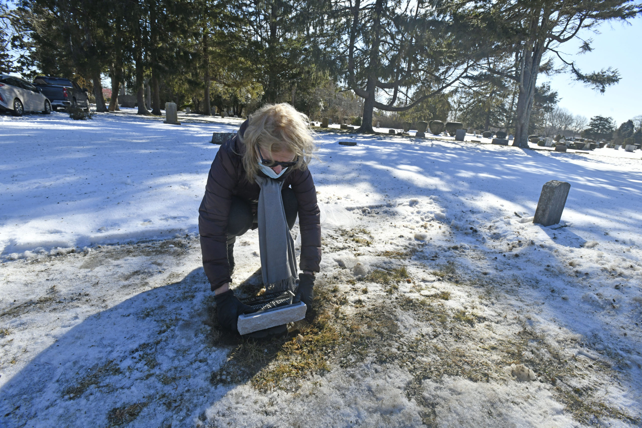 Janet O'Hare places a new headstone for her sister at the Southampton Cemetery on Thursday, February 4.  DANA SHAW