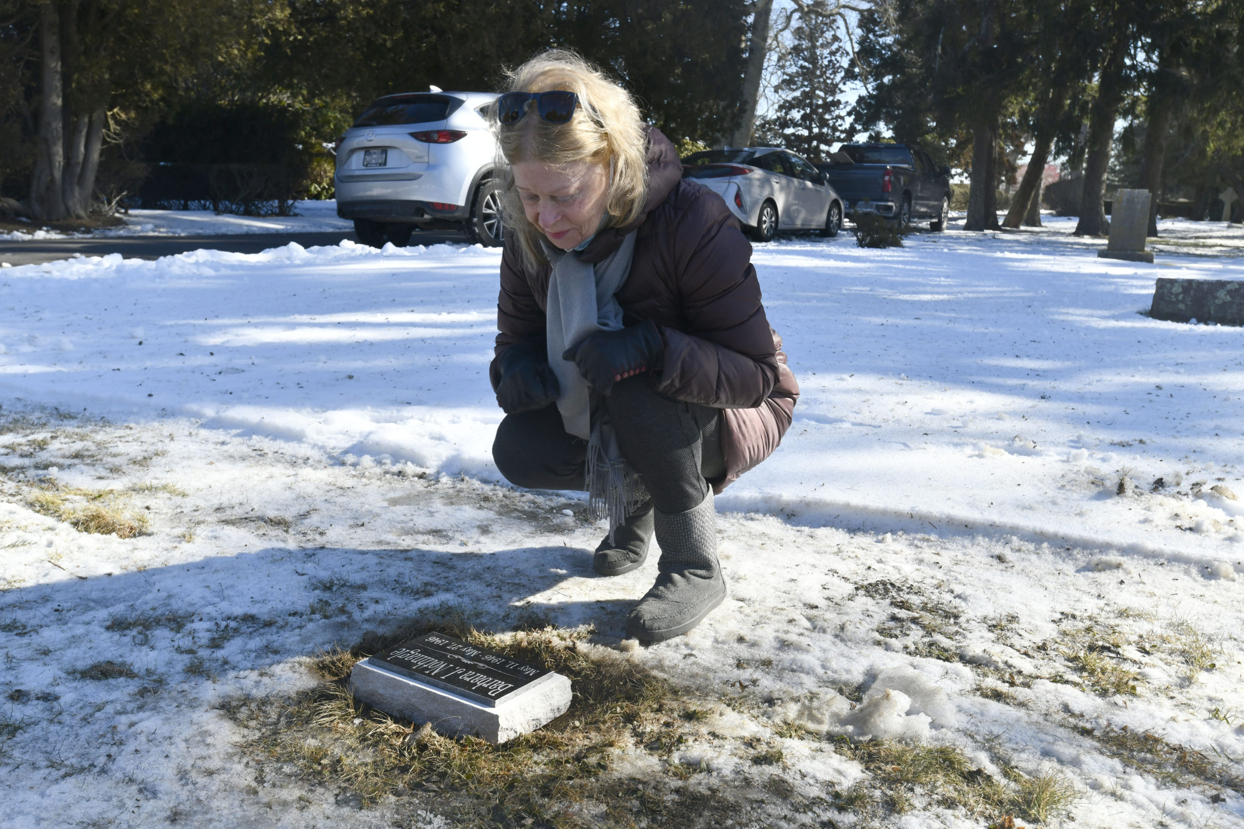 Janet O'Hare places a new headstone for her sister at the Southampton Cemetery on Thursday, February 4.  DANA SHAW