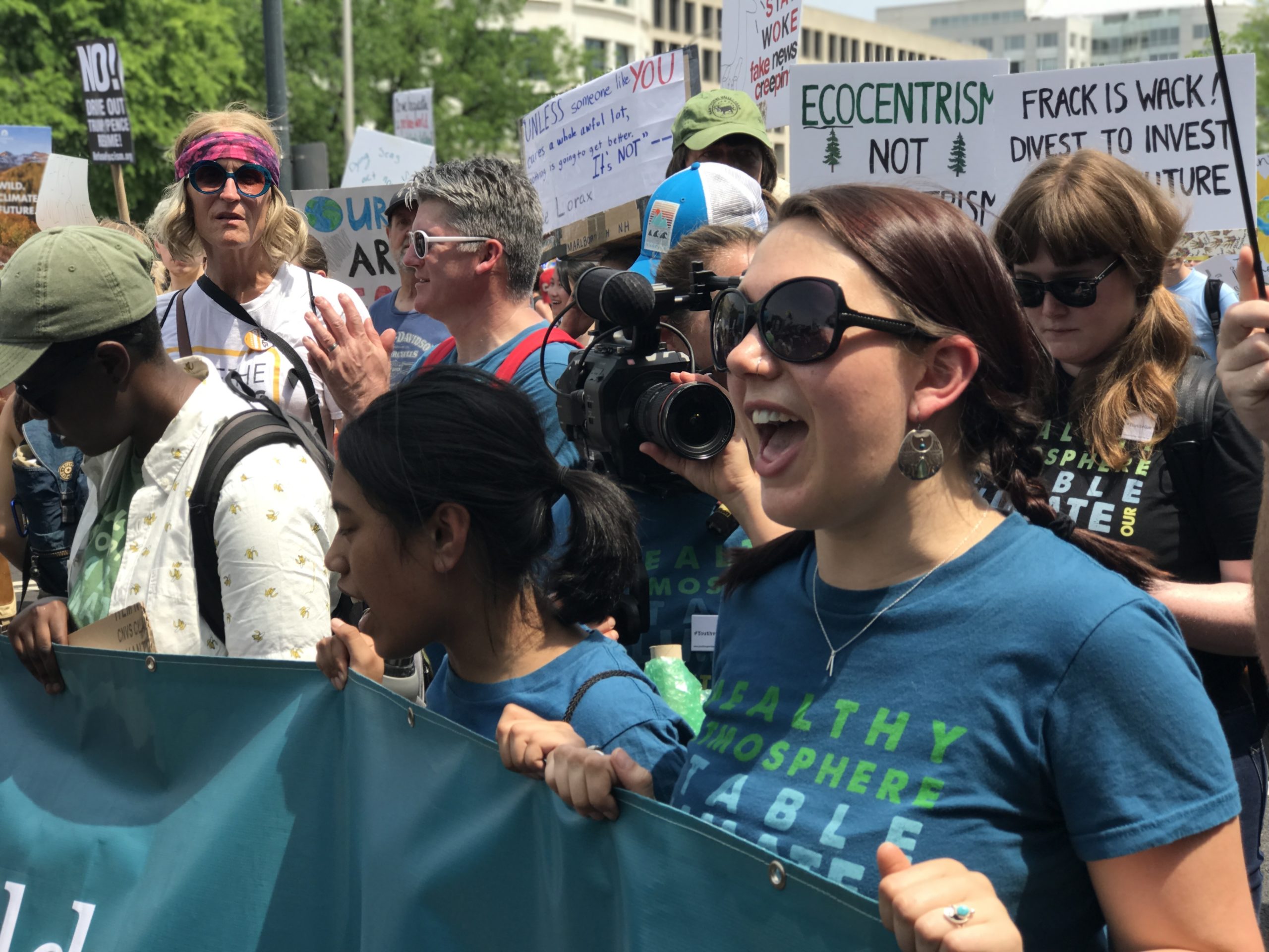 Director Christi Cooper, center, with camera, filming during a youth climate march.