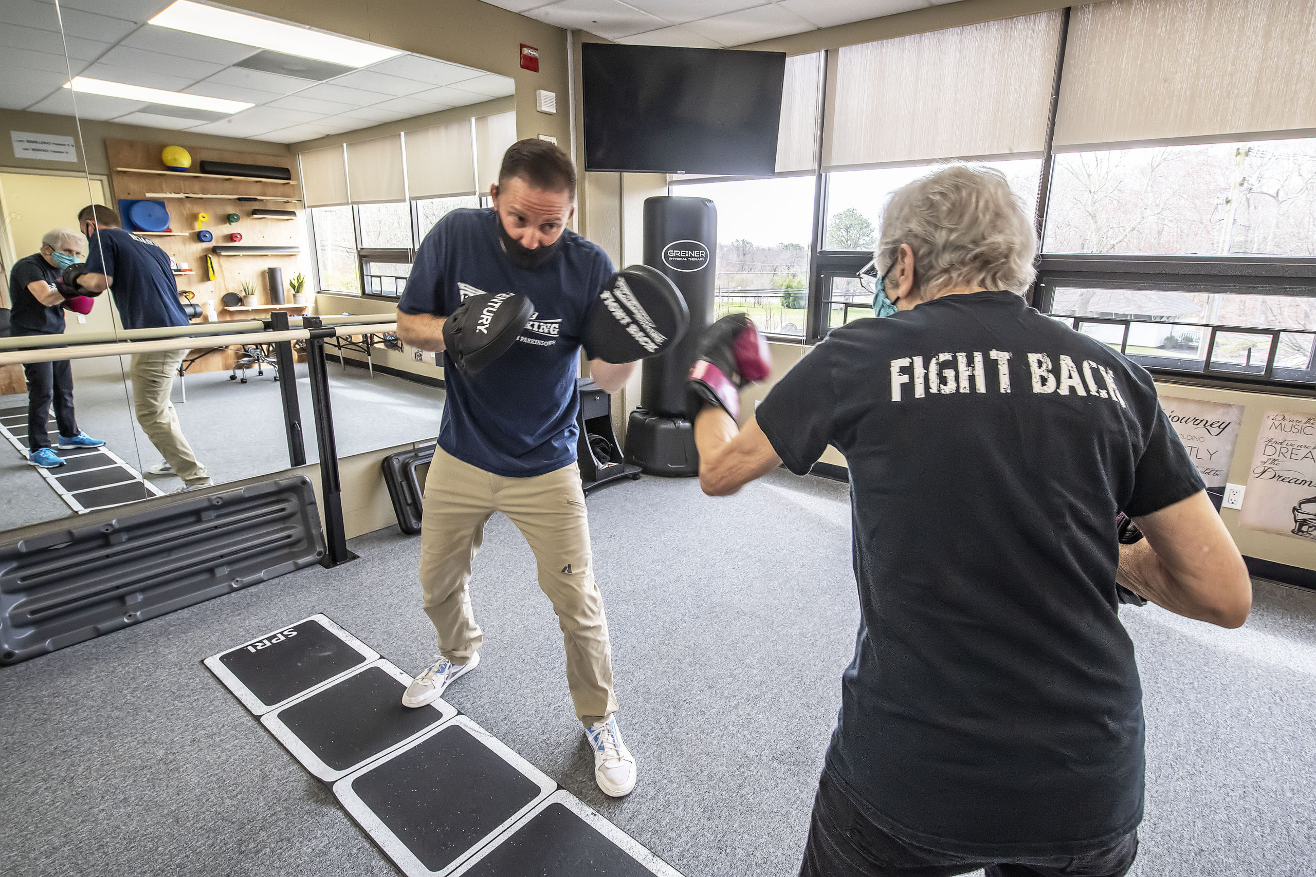 Seth Greiner of Greiner Physical Therapy does a Rock Steady Boxing workout with Parkinson's patient Janet Barr at the Greiner Physical Therapy studio in Speonk.