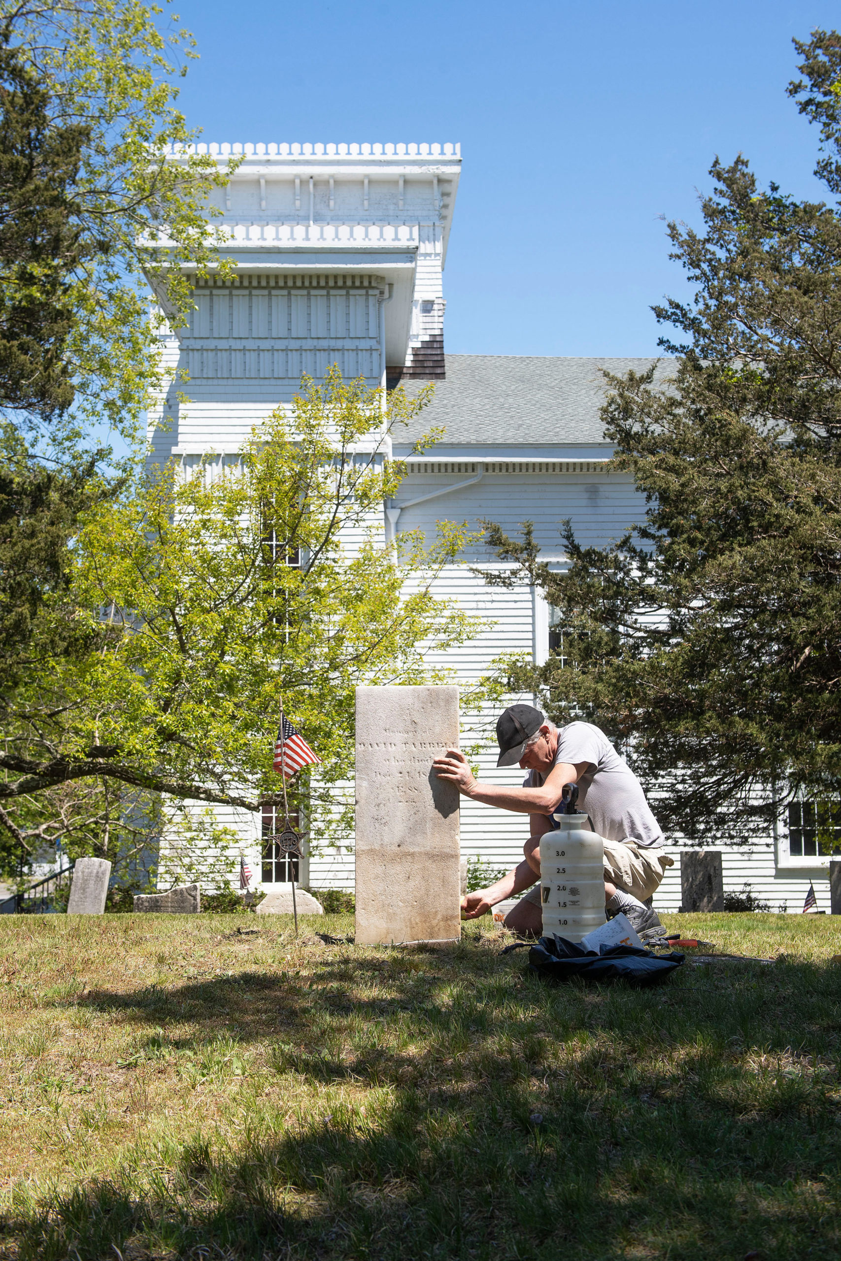 Burying Ground Preservation Group Partner Kurt Kahofer cleans a headstone during the early stages of the renovation and preservation process taking place at the Old Burying Ground adjacent to the Sag Harbor Old Whalers Church on May 11.    MICHAEL HELLER