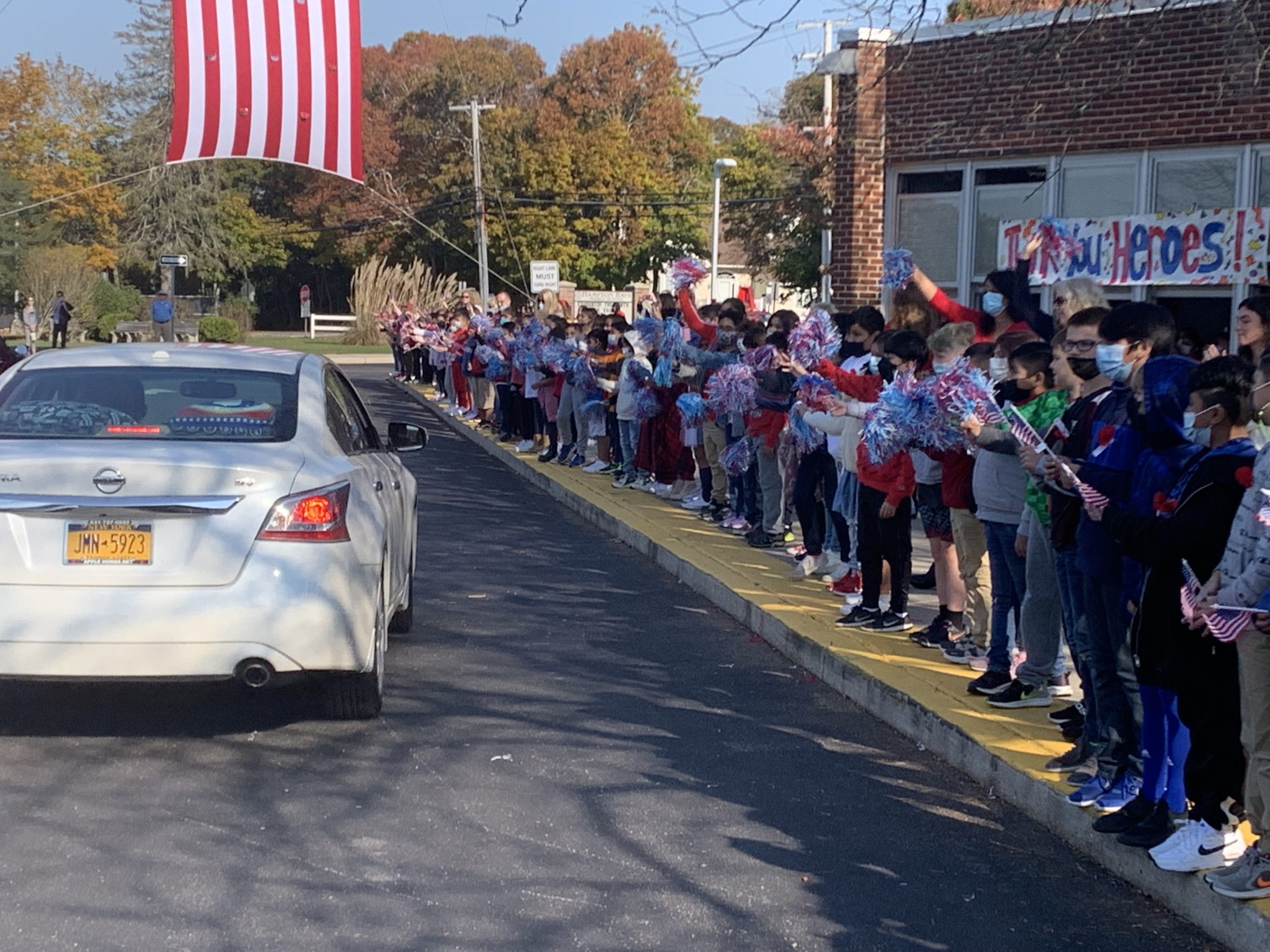 Hampton Bays veterans were honored during the second annual Veterans Day car parade at Hampton Bays Elementary School on November 10. Wearing red, white and blue and waving American flags and pompoms, the district’s fourth graders lined the school’s traffic circle to cheer on the veterans as patriotic music
played in the background. The celebratory parade culminated a week of learning about the importance of Veterans Day. Throughout the week, the students visited the American Legion and wrote songs, poems and essays about the meaning of Veterans Day.