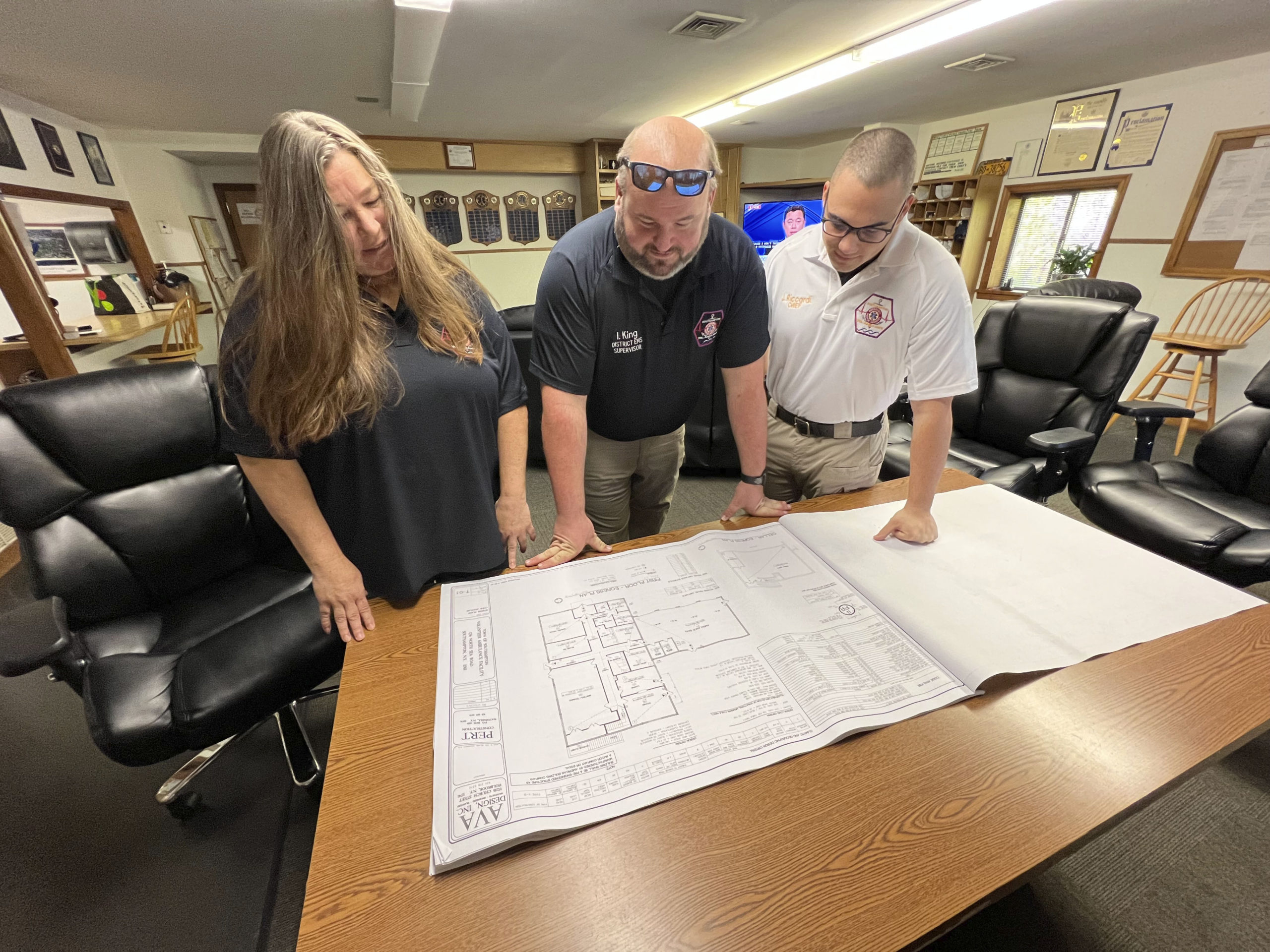Donna Kreymborg, Ian King and Joseph M. Riccardi look over plans for the new ambulance barn.     DANA SHAW