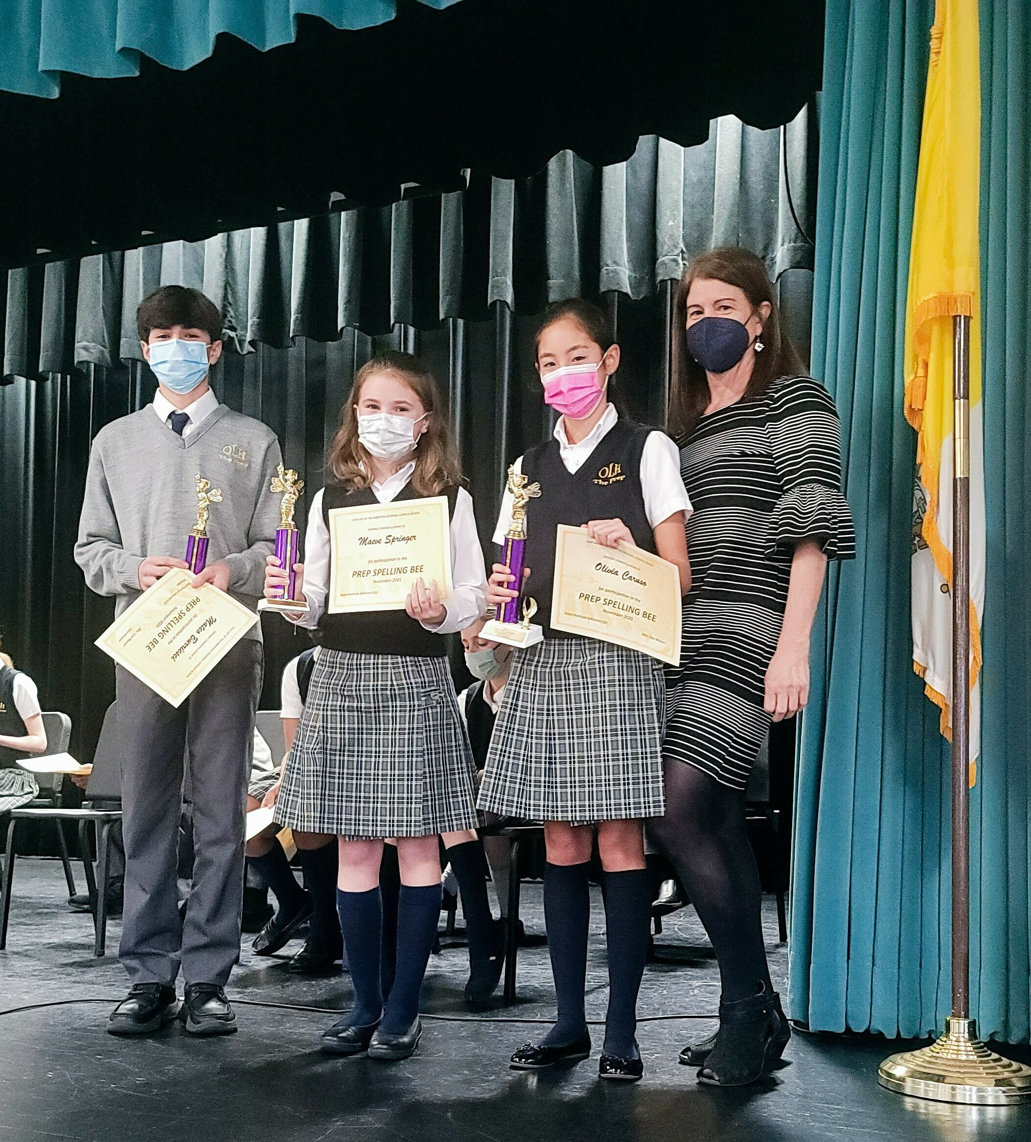 Winners of the Our Lady of the Hamptons School's Scripps Spelling Bee were, from left, Mateo Burriesci, third place; Maeve Springer, second place; and Olivia Caruso, first place; and coordinator Lisa Macari.