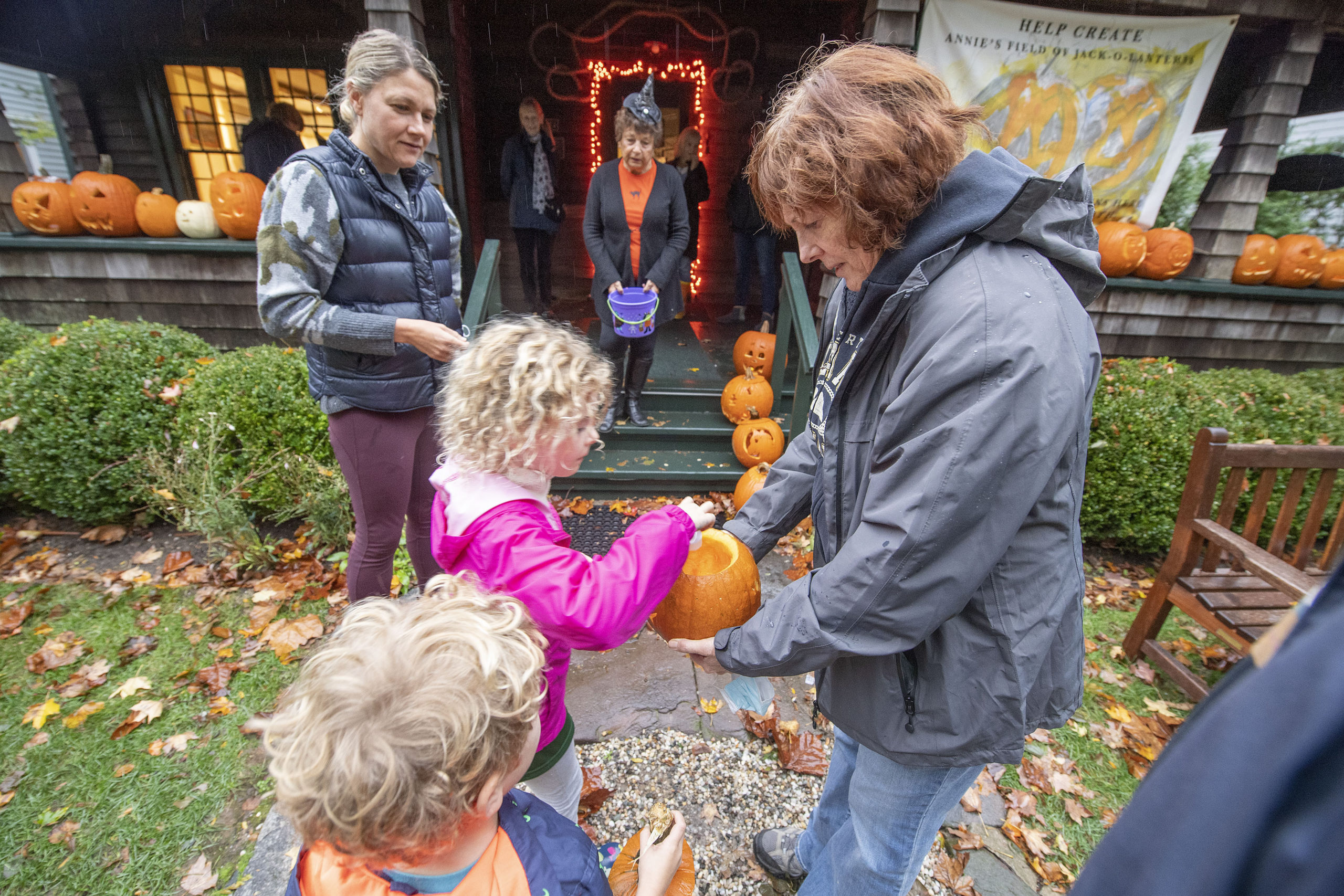 Owen and Lauren O'Neil add their decorated pumpkin to the display at the Sag Harbor Historical Society's Annie Cooper Boyd House on Saturday night.   MICHAEL HELLER