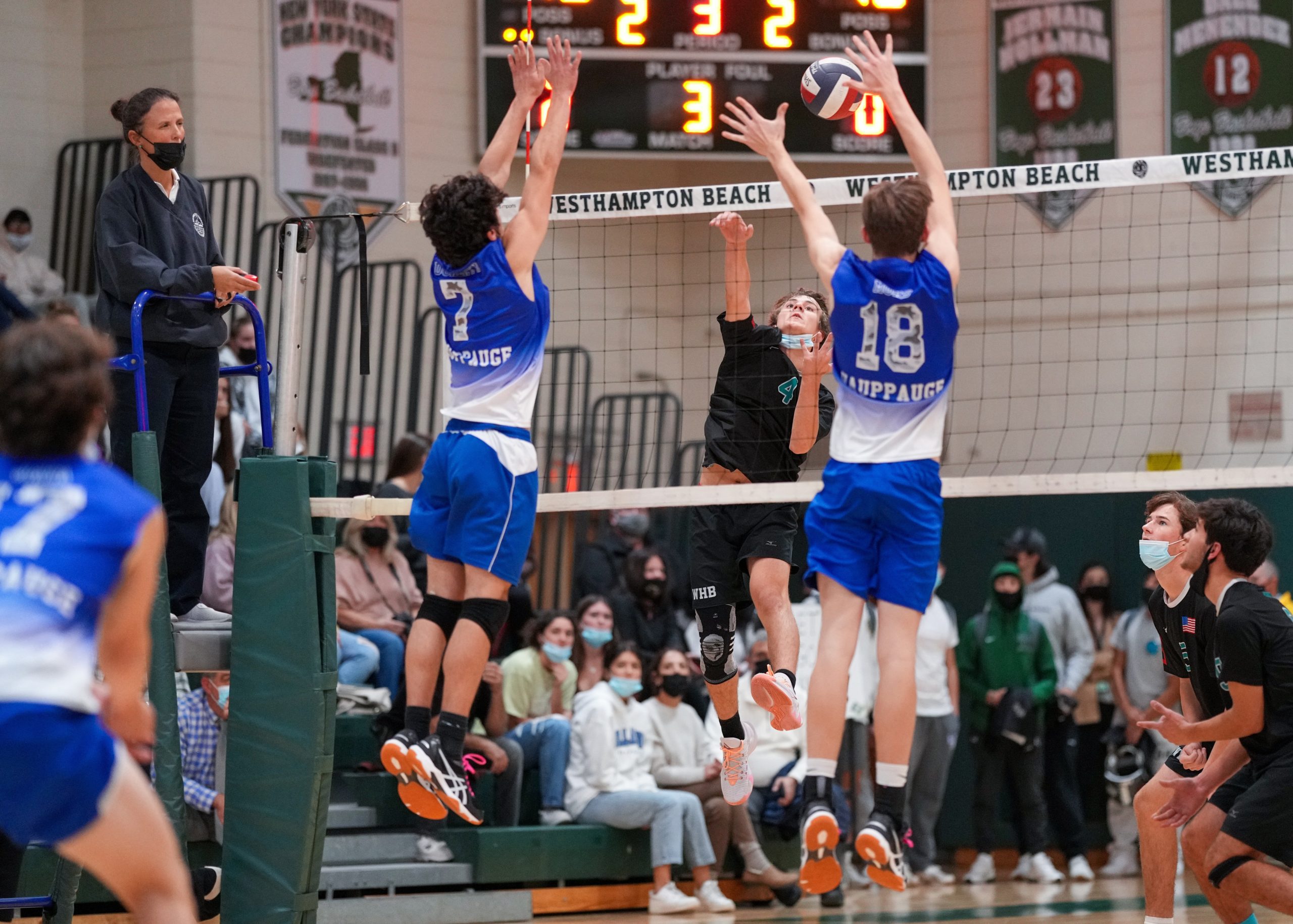 Westhampton Beach sophomore Seth Terry spikes the ball between Hauppauge opponents. RON ESPOSITO