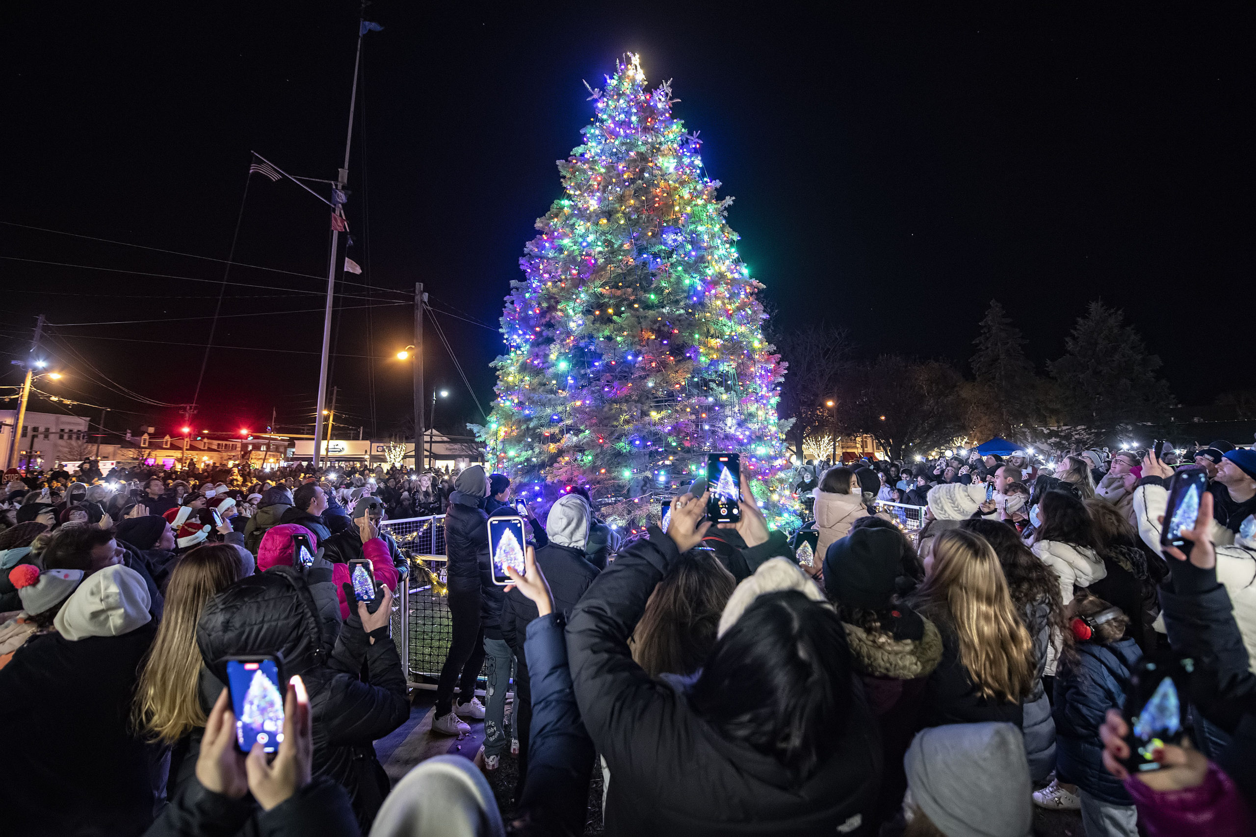The crowd reacts as the lights come on during the Christmas Tree Lighting Ceremony in Agawam Park on Saturday night.  MICHAEL HELLER