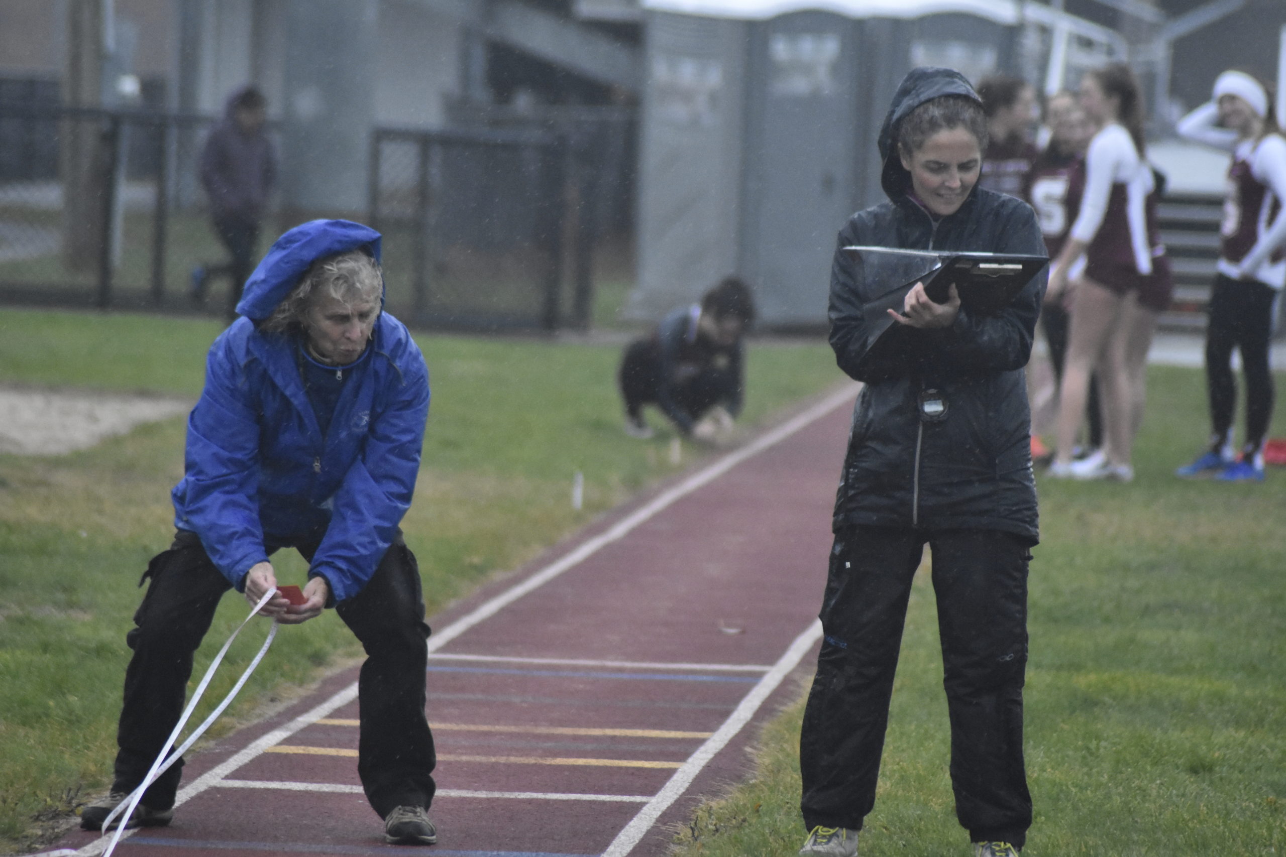 East Hampton girls track head coach Yani Cuesta tries to record some results in the rain.