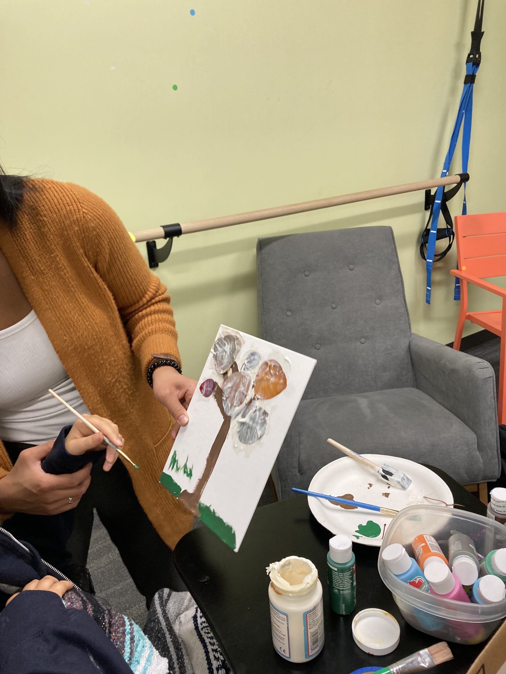 Bella Adlah paints during occupational therapy at Re+active Physical Therapy in California.