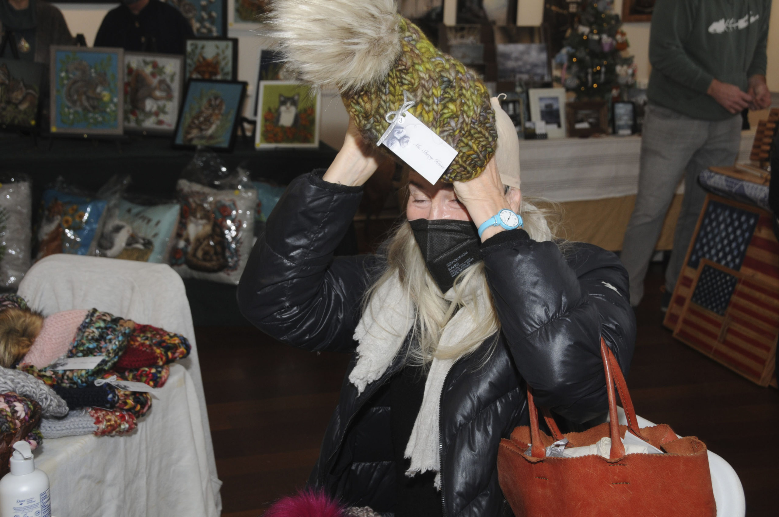 Kate Zahorsky tries on a hat at the Ashawagh Hall in Springs on Saturday were able to see and purchase artwork and crafts in a broad variety of media, from wood, metal, ceramics, paint and more, at the 11th Annual Friends Bazaar.    RICHARD LEWIN