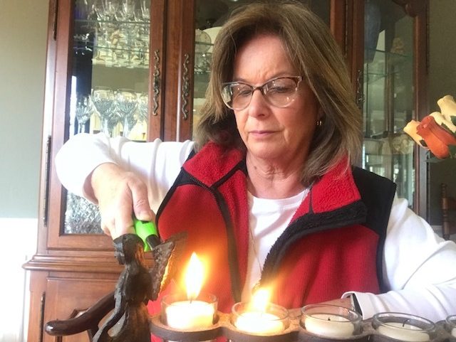 Jean Behrens, the adult bereavement coordinator at East End Hospice, lights candles in memory of her loved ones during the holidays.