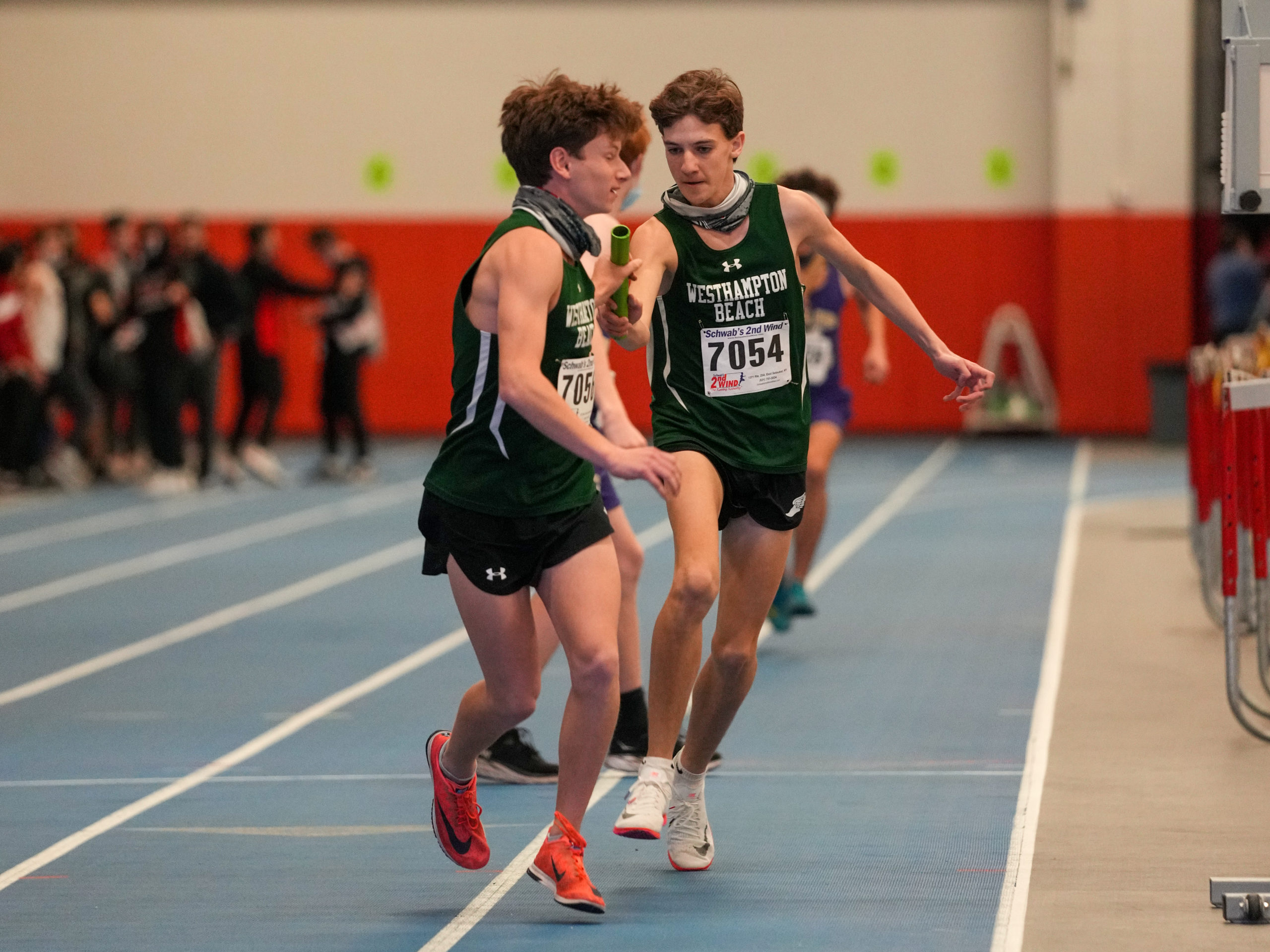 Trevor Hayes hands off to his Hurricane teammate Max Haynia in the 4x800-meter relay on Saturday.