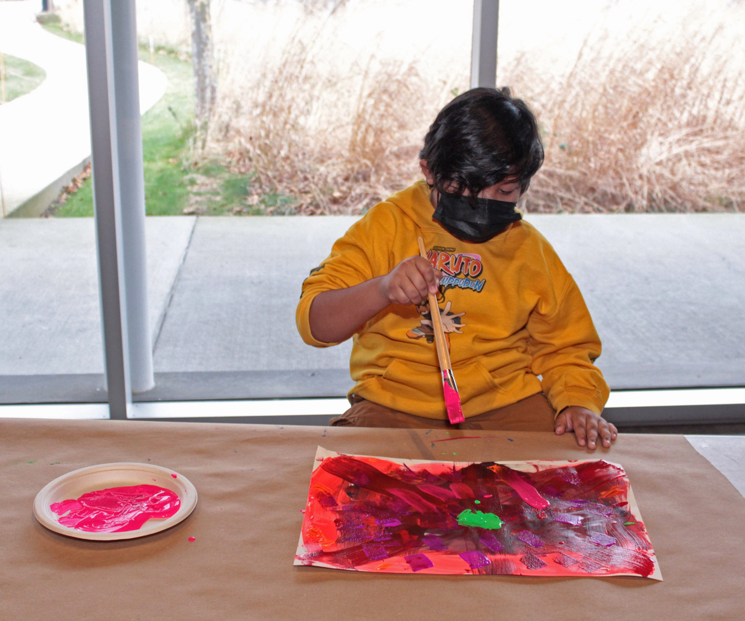 A student contributes to a painting during 