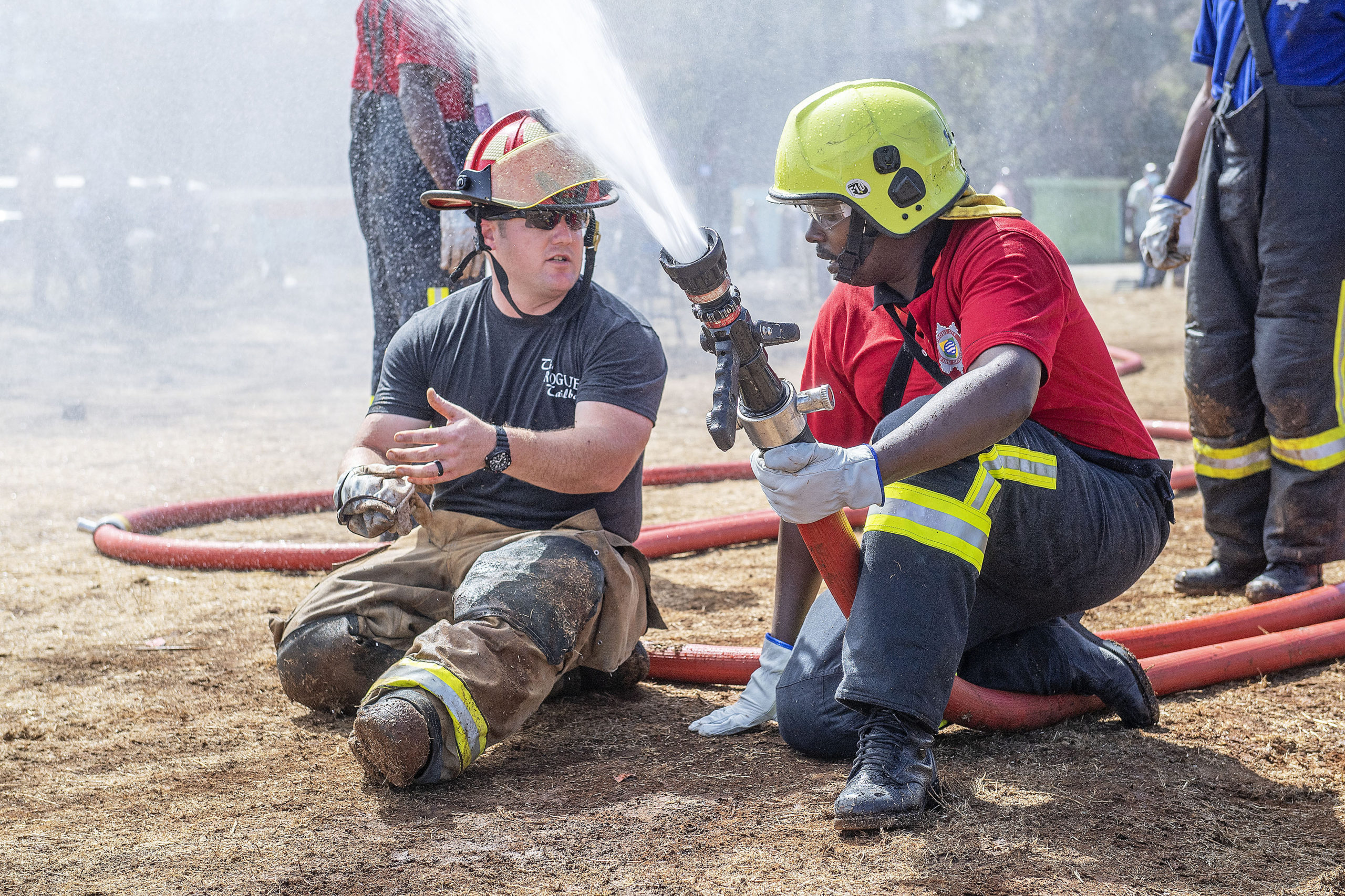 Texas firefighter John Moore gives advice on hose-handling techniques to a Kenyan firefighter during the Africa Fire Mission November trip to Nairobi, Kenya.