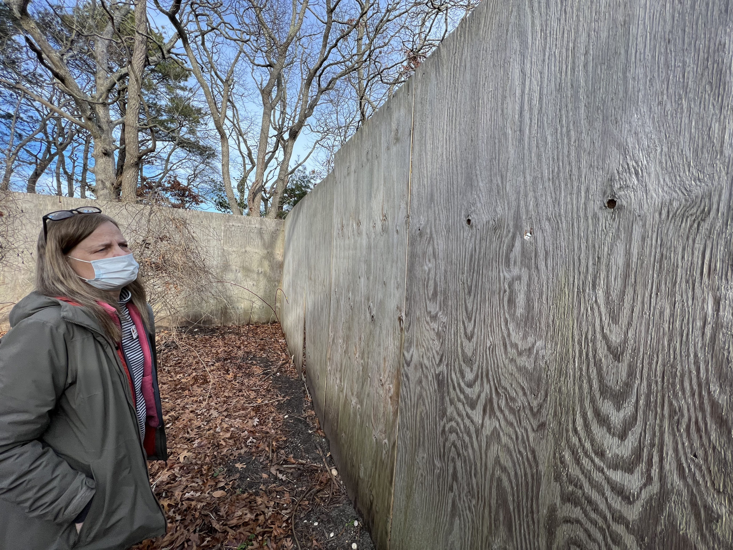 Evelyn Alexander Wildlife Rescue Center Executive Director stands near the location of another bullet hole.   DANA SHAW