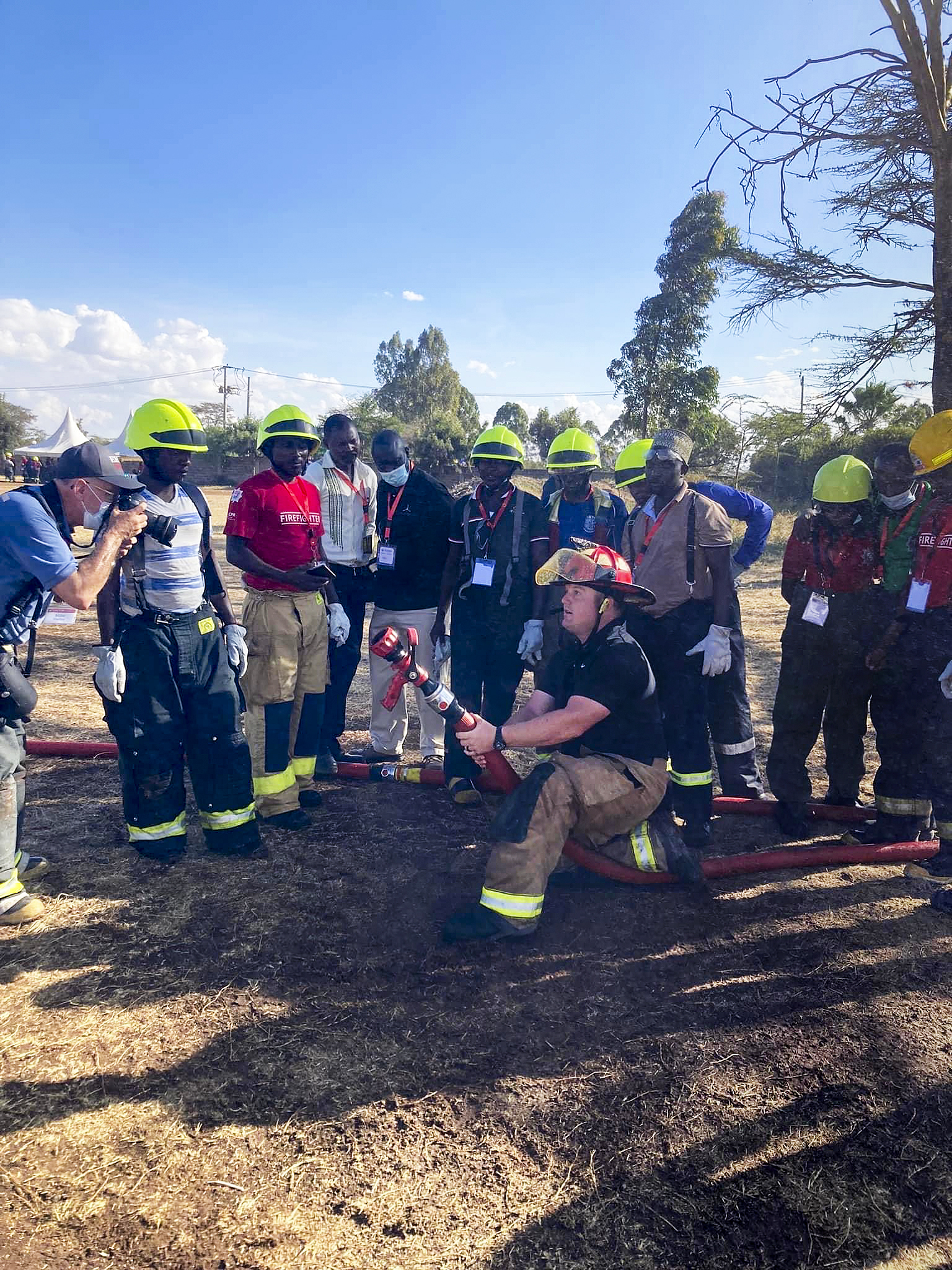 East Hampton Fire Department firefighter Michael Heller photographs Texas firefighter John Moore as he helps to train Kenyan firefighters with hose-handling techniques during the Africa Fire Mission trip to Kenya, Nairobi.