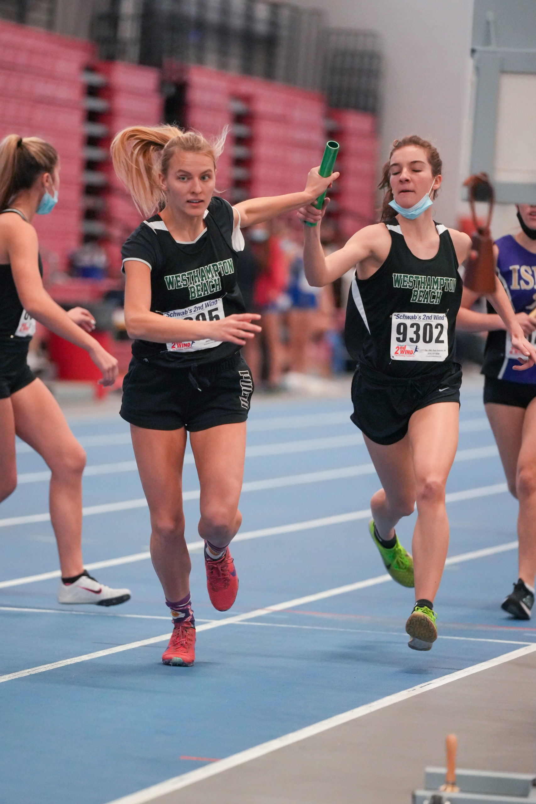Valerie Finke takes the baton from Westhampton Beach relay mate Rose Hayes.