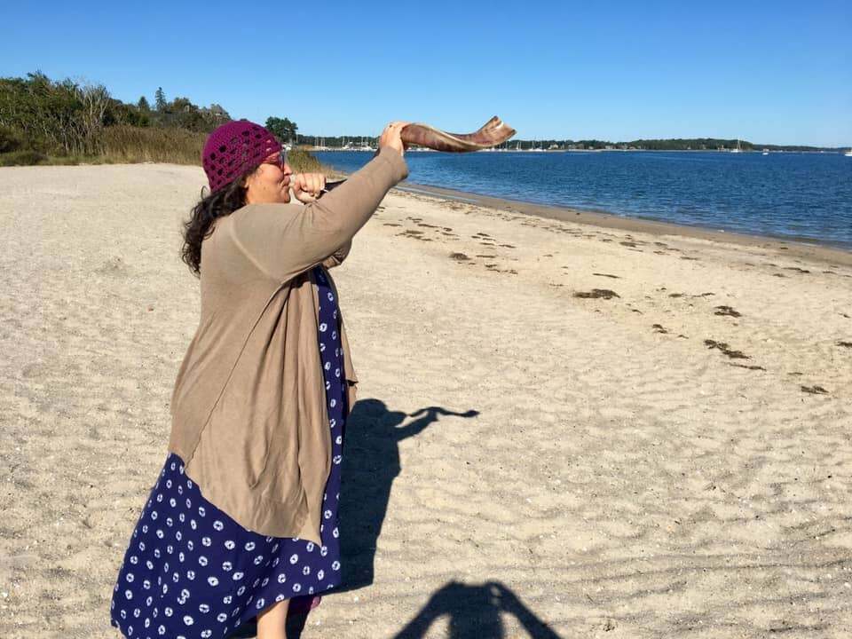 Rabbi Minna Bromberg with the shofar on the beach.