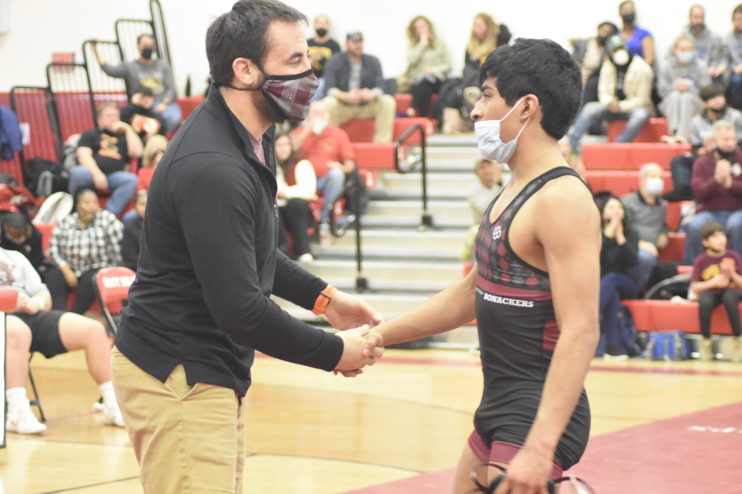 East Hampton head coach Ethan Mitchell shakes the hand of his senior Caleb Peralta after he suffered a 12-2 loss to Vin Ziccardi of Kings Park in the League V Championships.