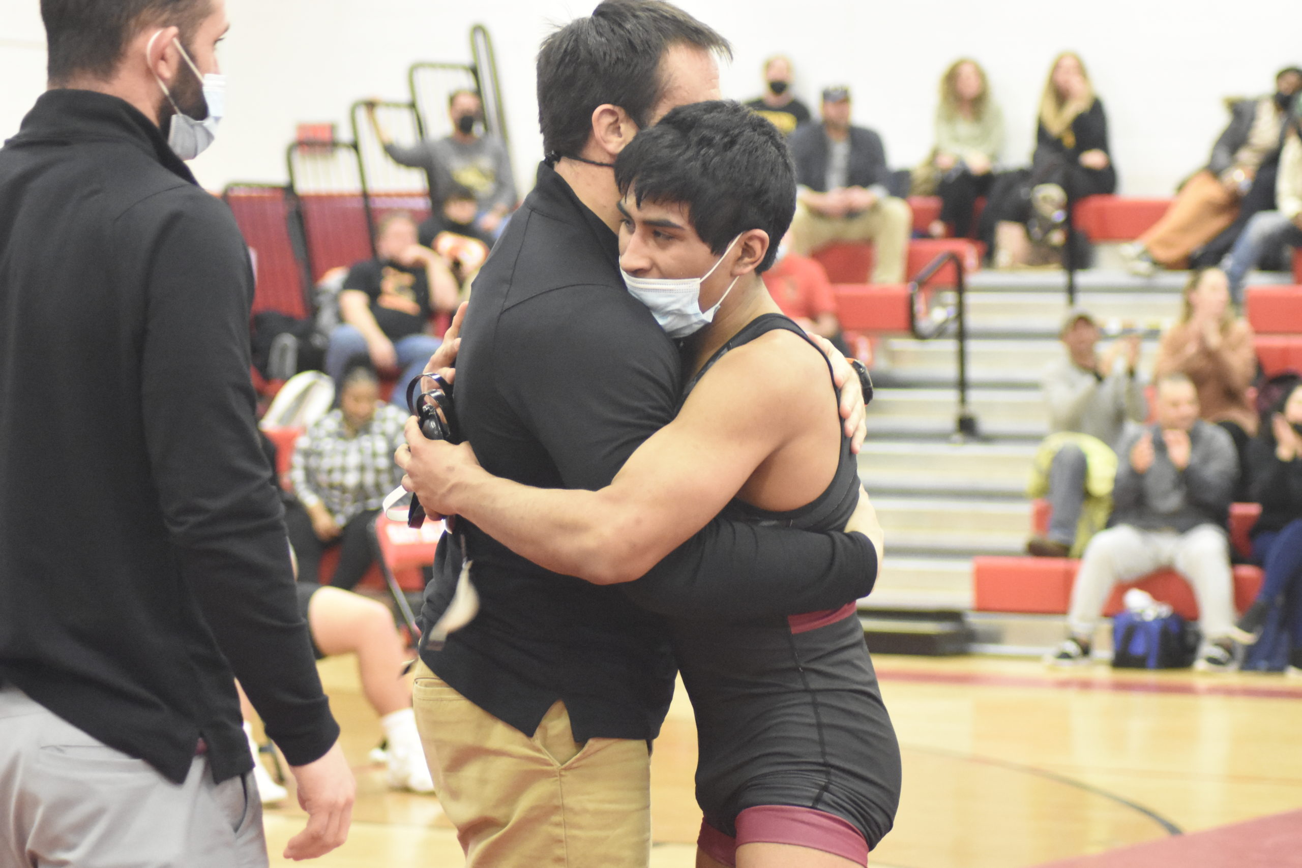 East Hampton head coach Ethan Mitchell and senior Caleb Peralta embrace one another after he suffered a 12-2 loss to Vin Ziccardi of Kings Park in the League V Championships.