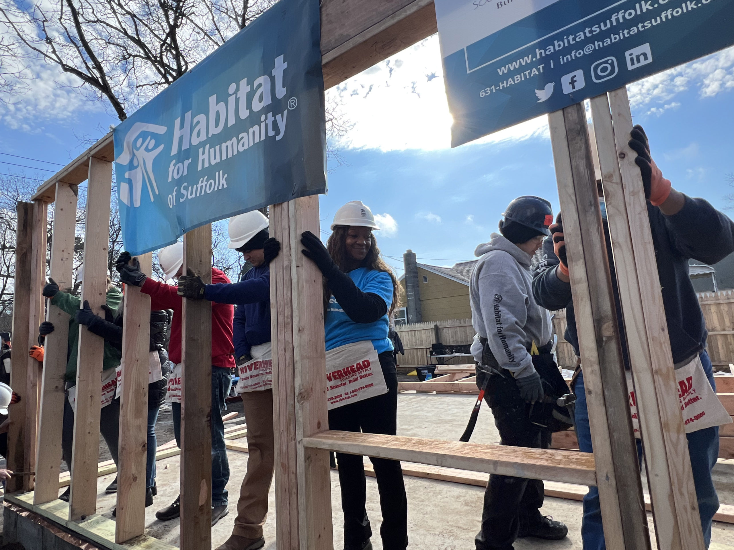 Homeowner Sahlise Cherry  raises a wall of her house with Habitat for Humanity volunteers.  DANA SHAW
