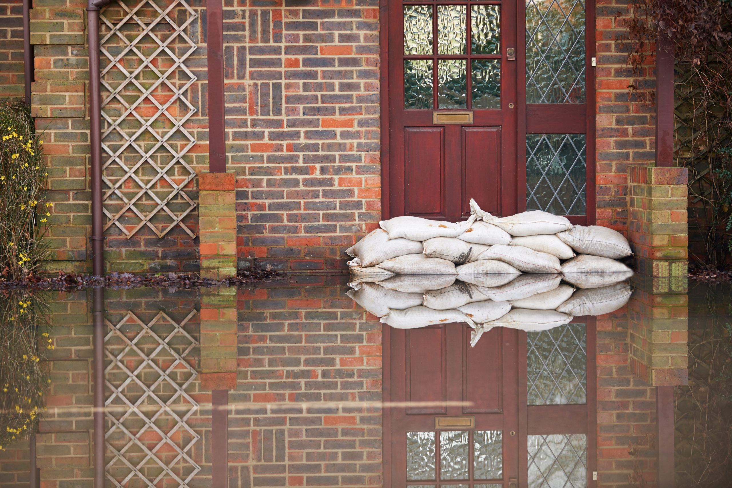 Sandbags outside of the front door of a flooded house.