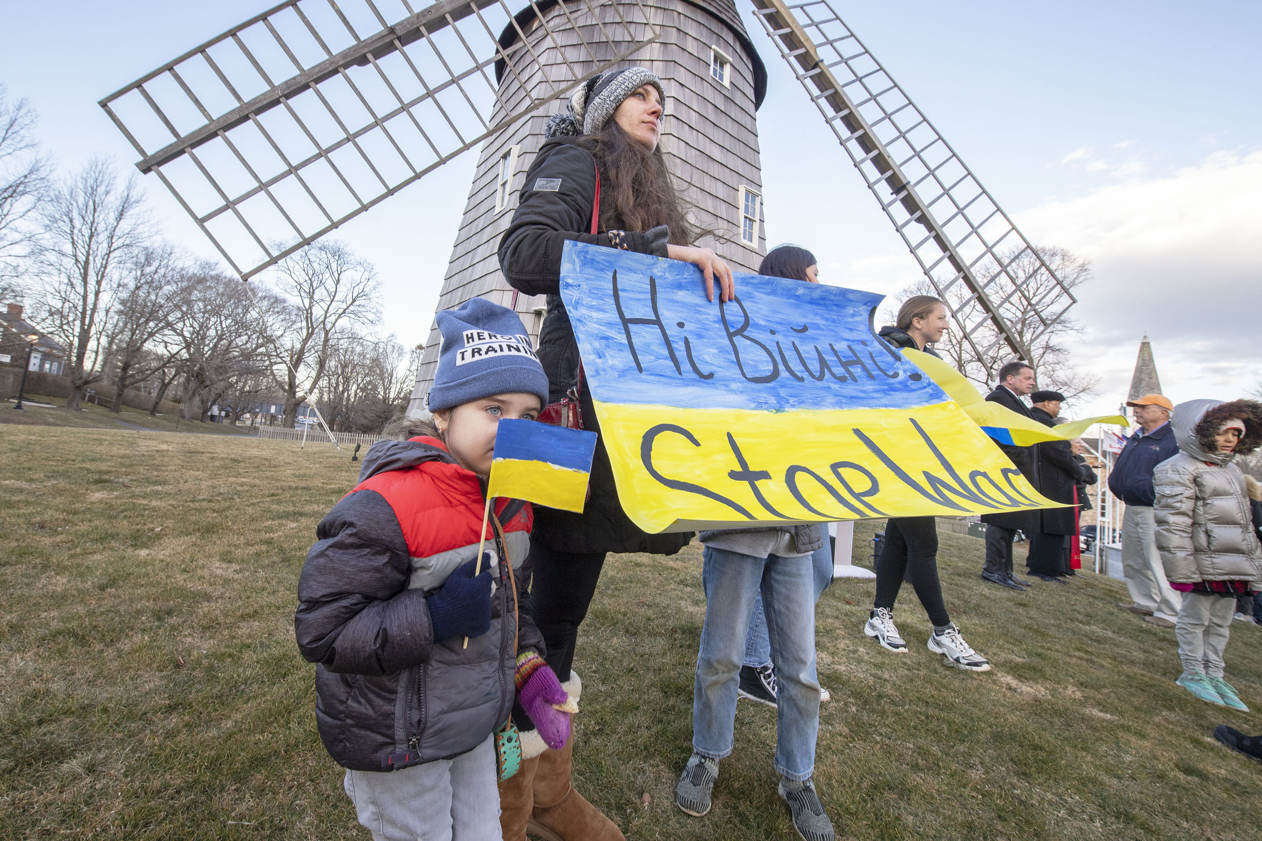 Zoe Ostrof, holding a Ukrainian flag that she made herself, looks on with her mom, Anna, and brother, Jayden, during a rally last Thursday in support of Ukraine on the Hook Mill Village Green in East Hampton. MICHAEL HELLER