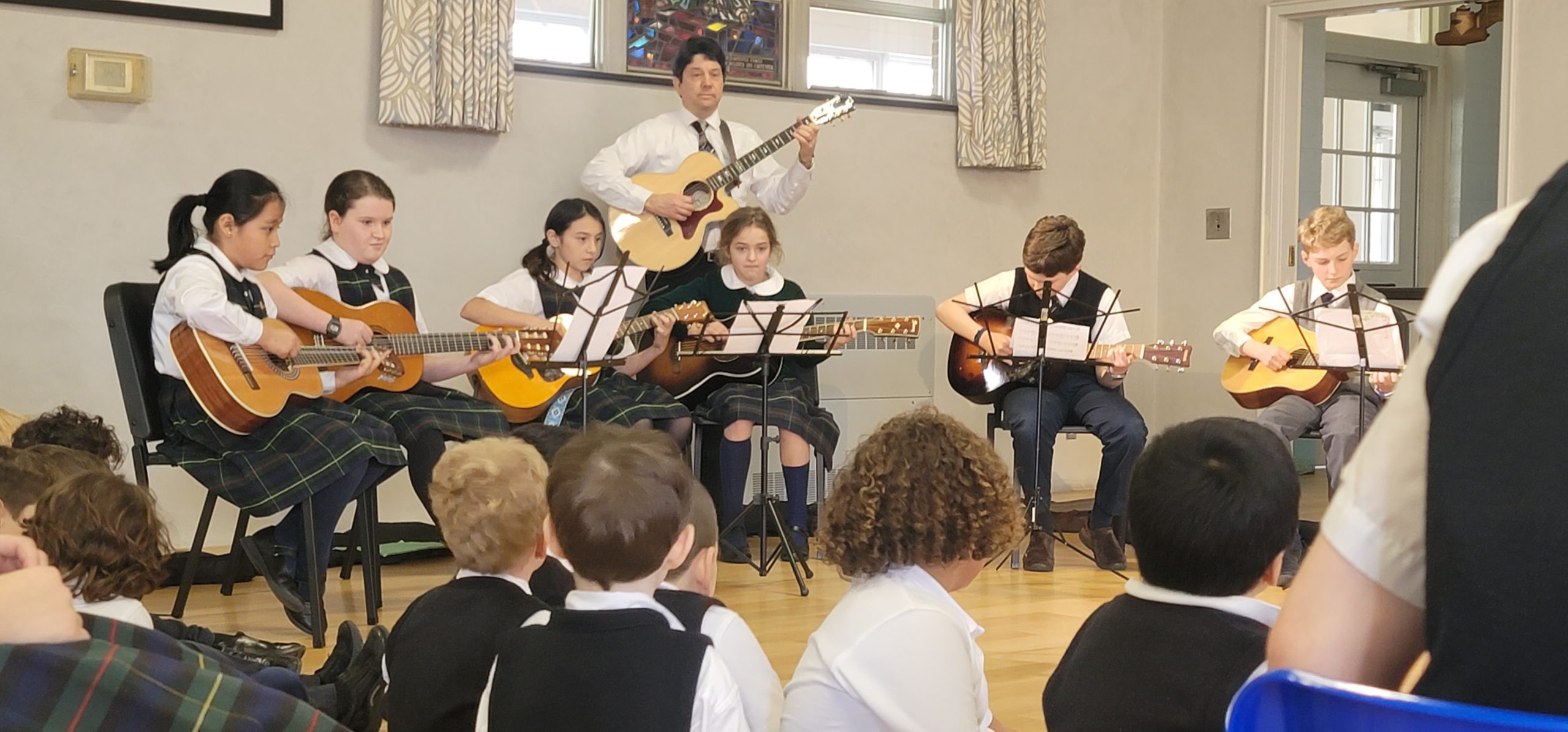 The Our Lady of the Hamptons School guitar group performing at a recent school assembly.
