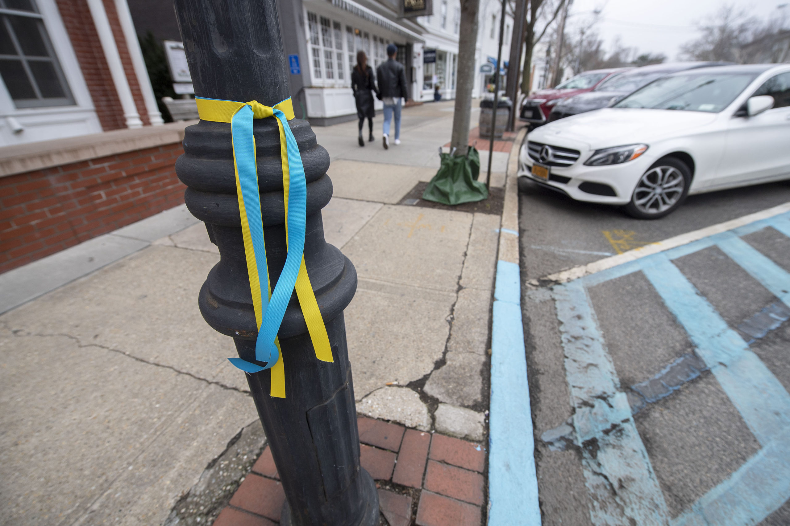 Blue and yellow ribbons were tied around all the street lampposts on Main Street in Sag Harbor in support of Ukraine, as seen on Monday. MICHAEL HELLER