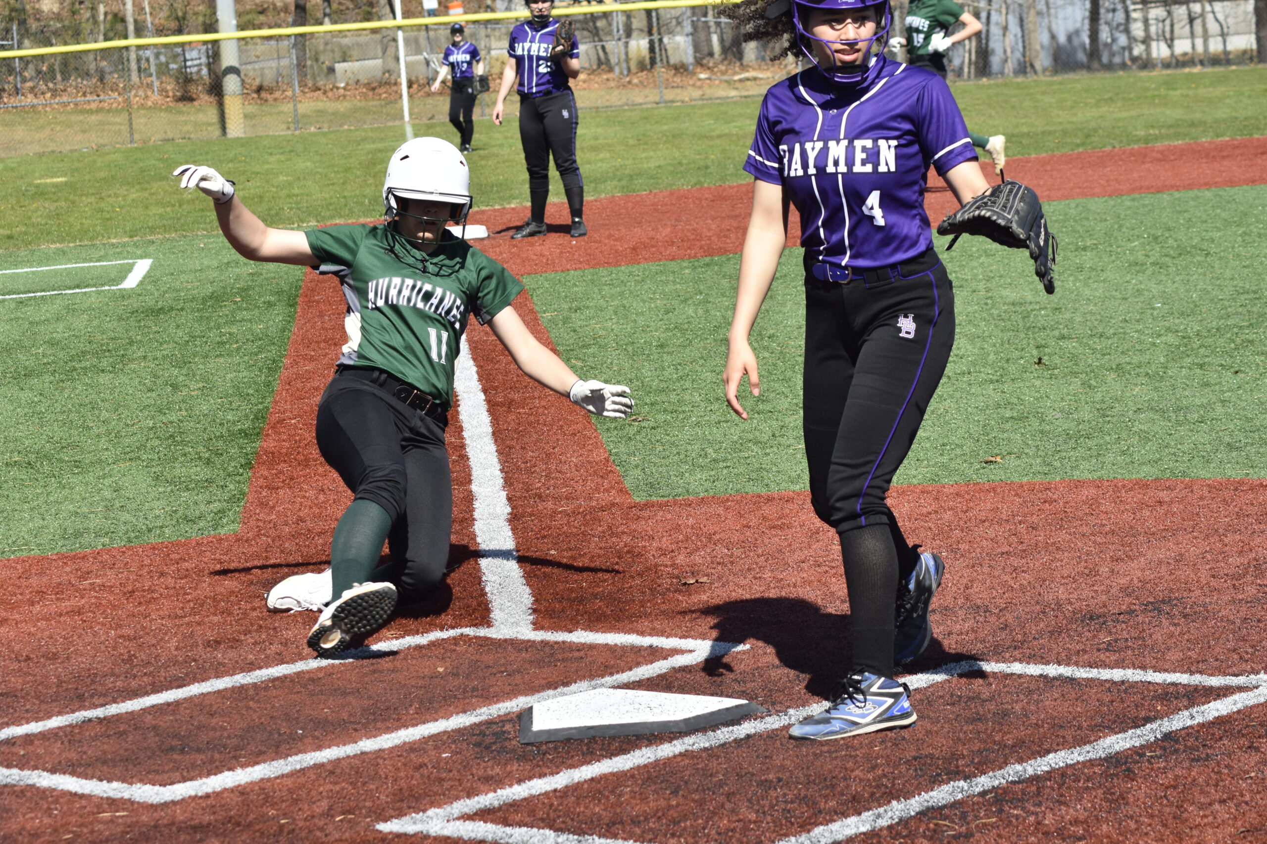 Addison Celi slides in safely to home plate for the Hurricanes.   DREW BUDD