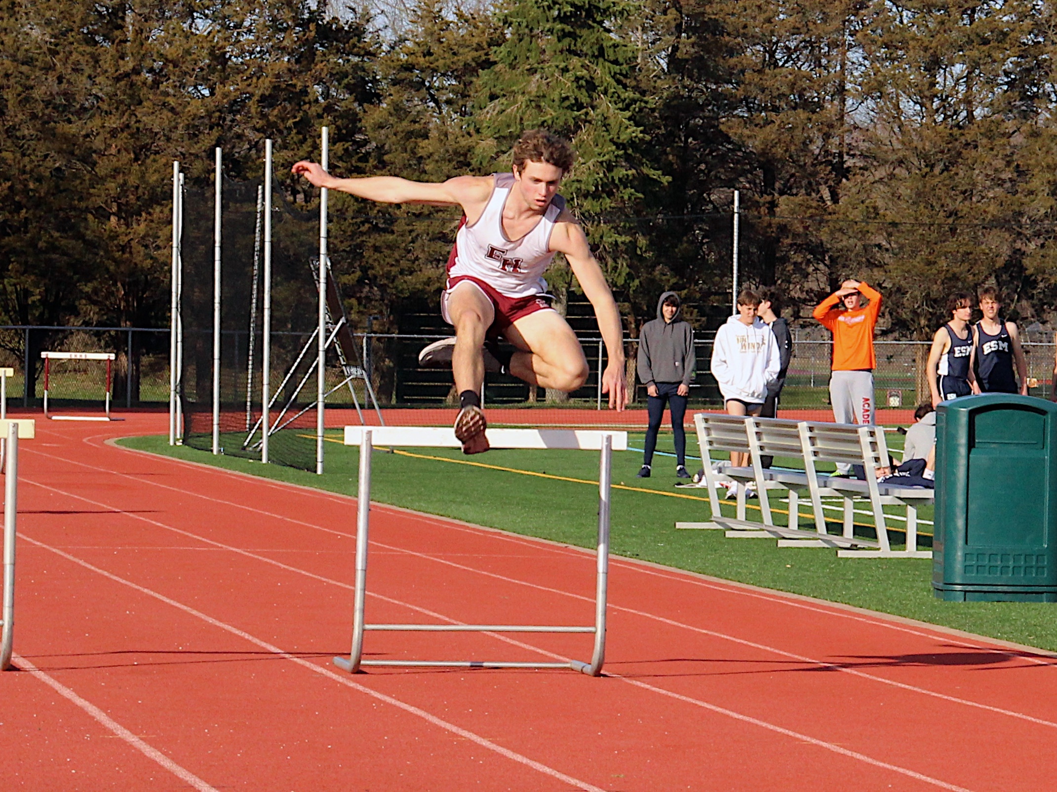 East Hampton senior Evan Masi leaps over a hurdle during Monday's meet.  KYRIL BROMLEY