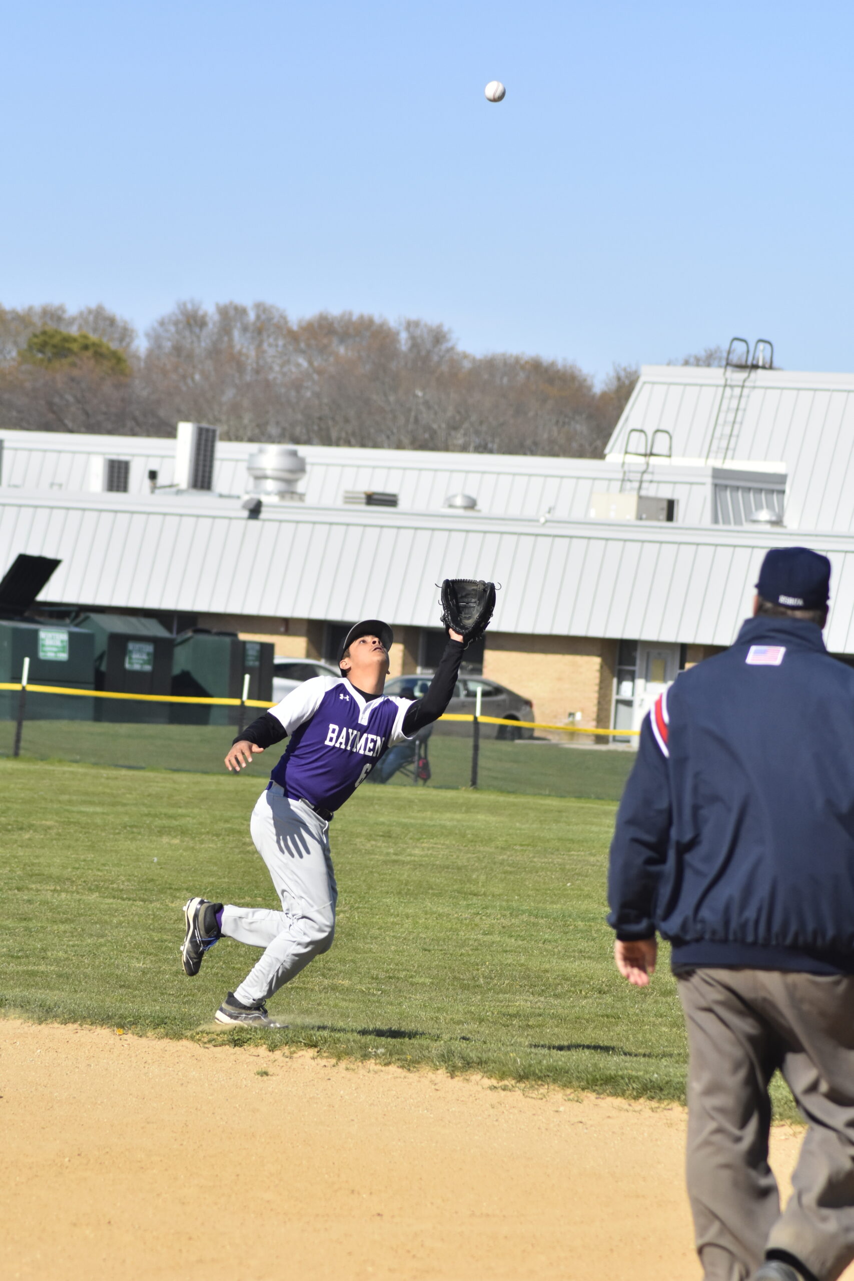Hampton Bays second baseman Eustorgio Urbano lines up a fly ball in shallow right field.    DREW BUDD