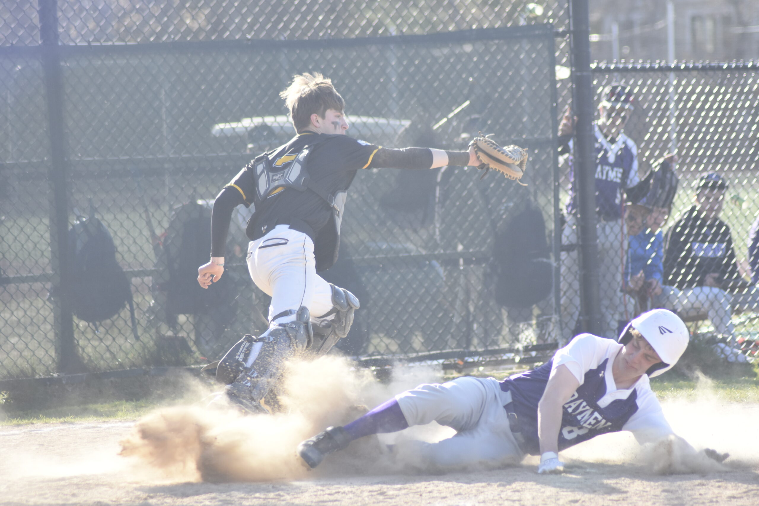 A Hampton Bays player slides safely ahead of a throw at home plate for a run.   DREW BUDD