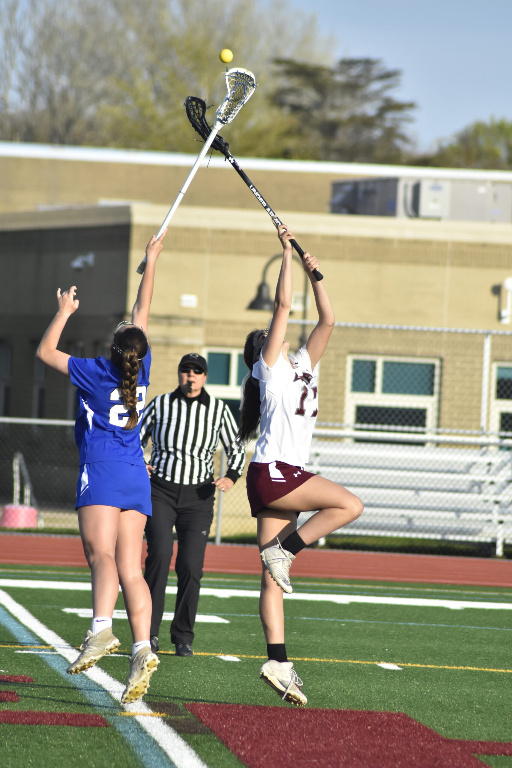 East Hampton sophomore Melina Sarlo and a Glenn player go for the ball off the opening faceoff.   DREW BUDD
