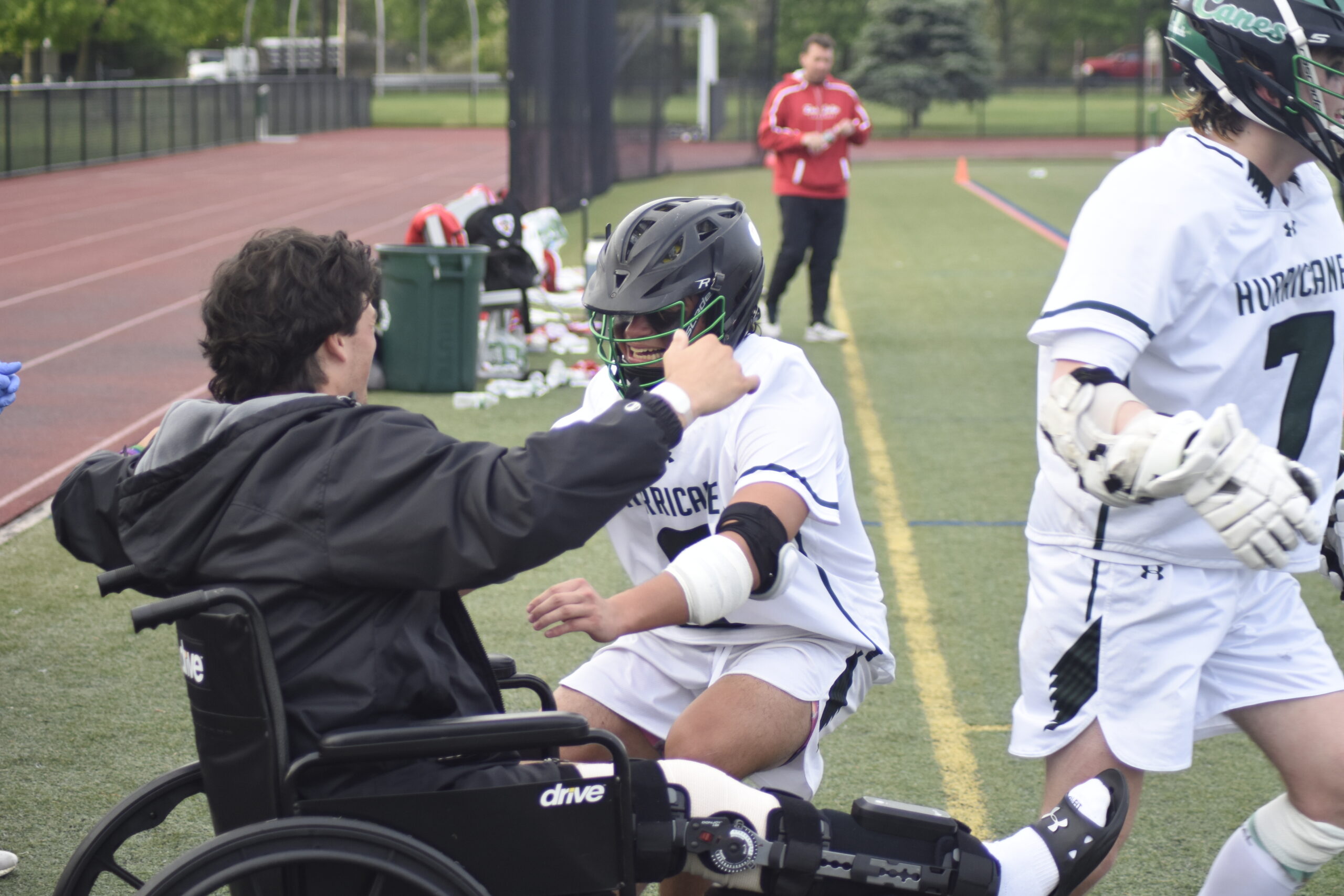 Ethan Faralan runs over to injured classmate Geoff Arrasate to celebrate the team's victory.   DREW BUDD