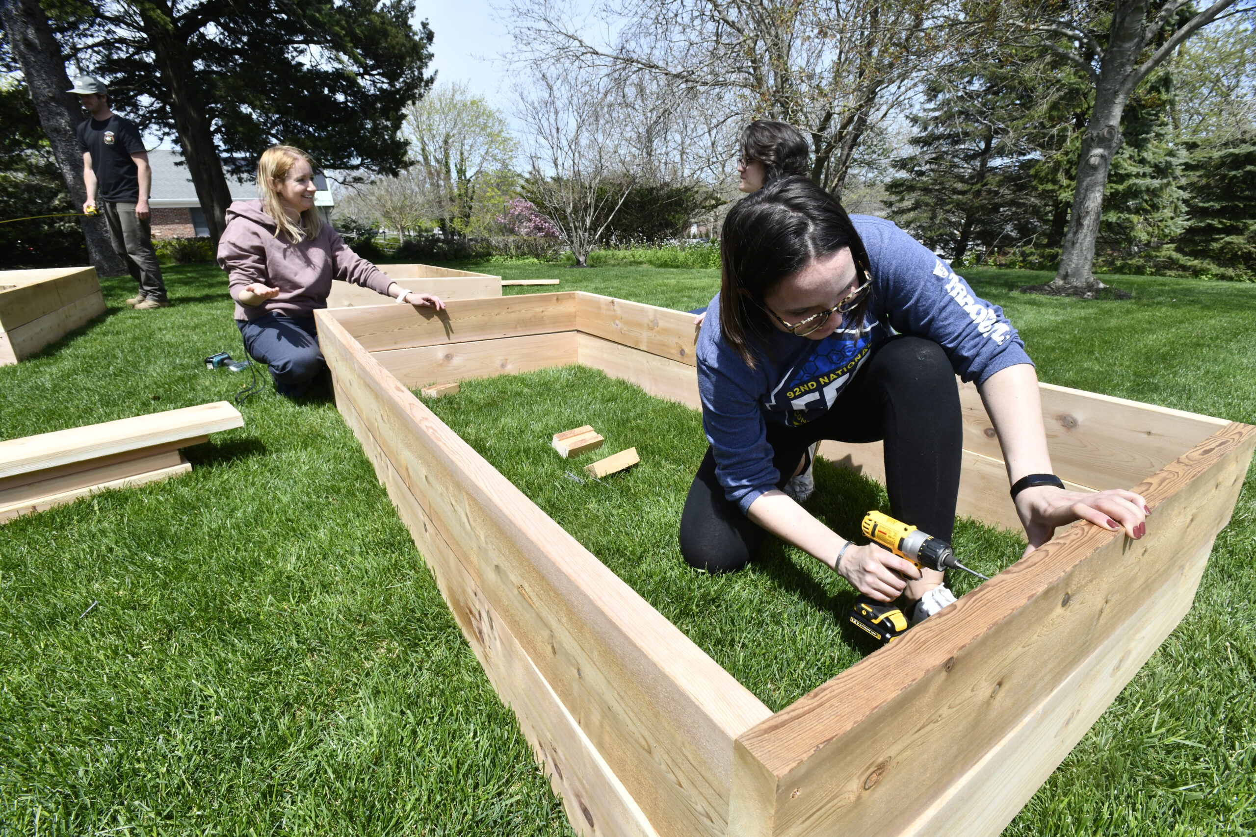 Joanna Faron, Sara Fiore and Scout Mercer work on building the frames for the garden.   DANA SHAW